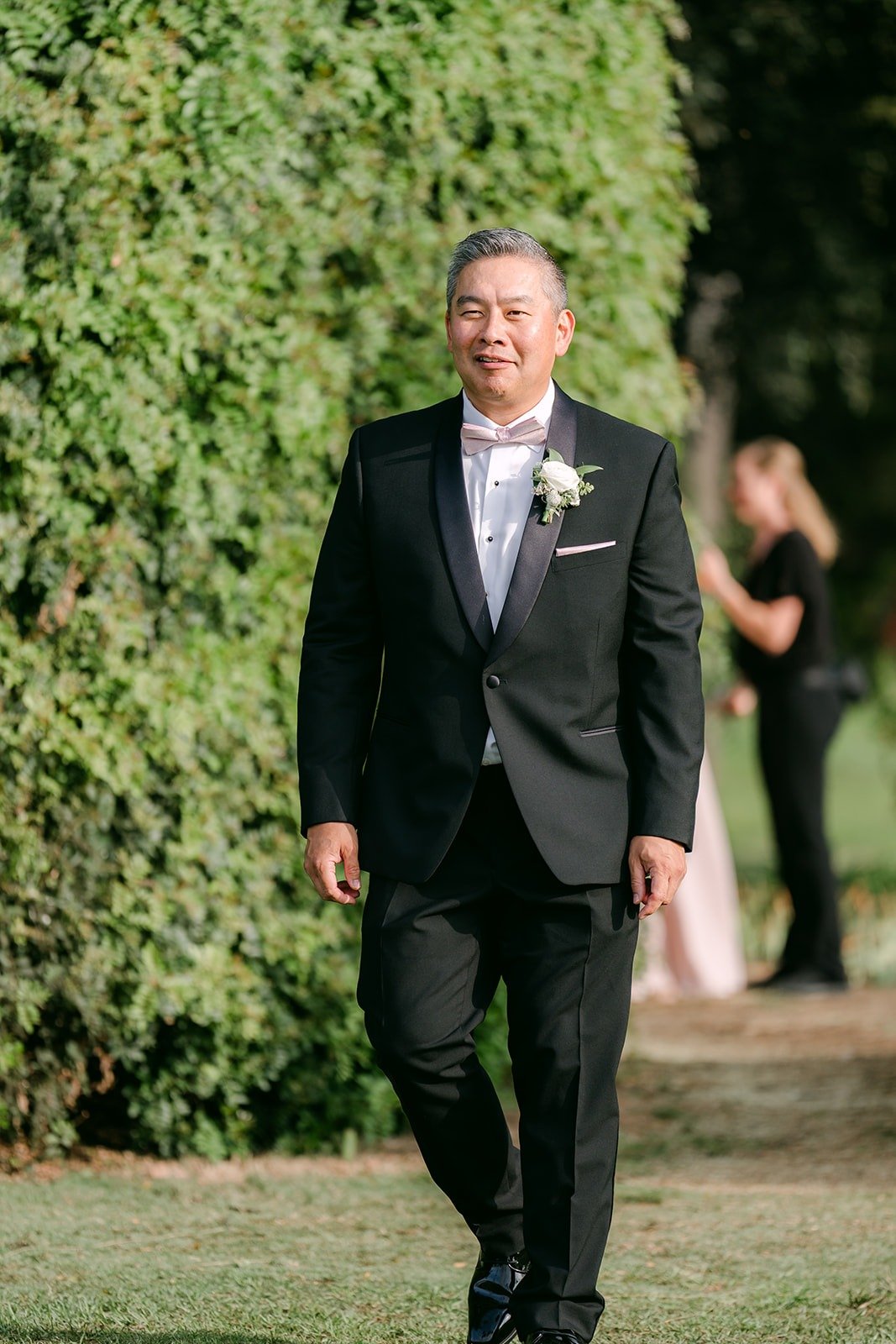 A family member walking down the aisle in a black suit