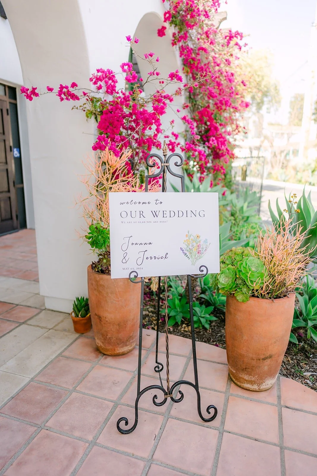 The welcome sign under pink bougainvillea in the La Ventura courtyard