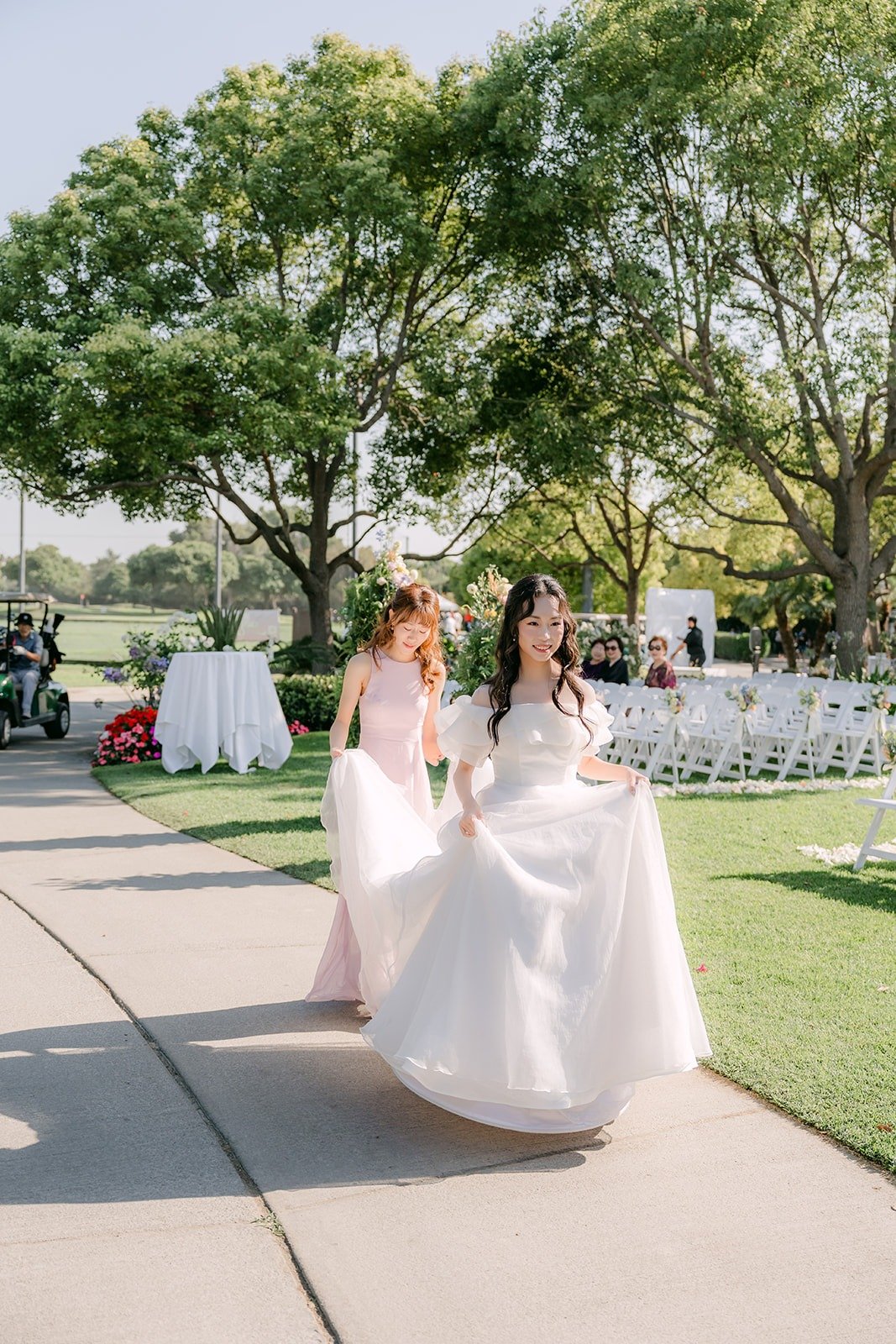 Jeannie walking toward the green for her first look as Stephanie carries her train