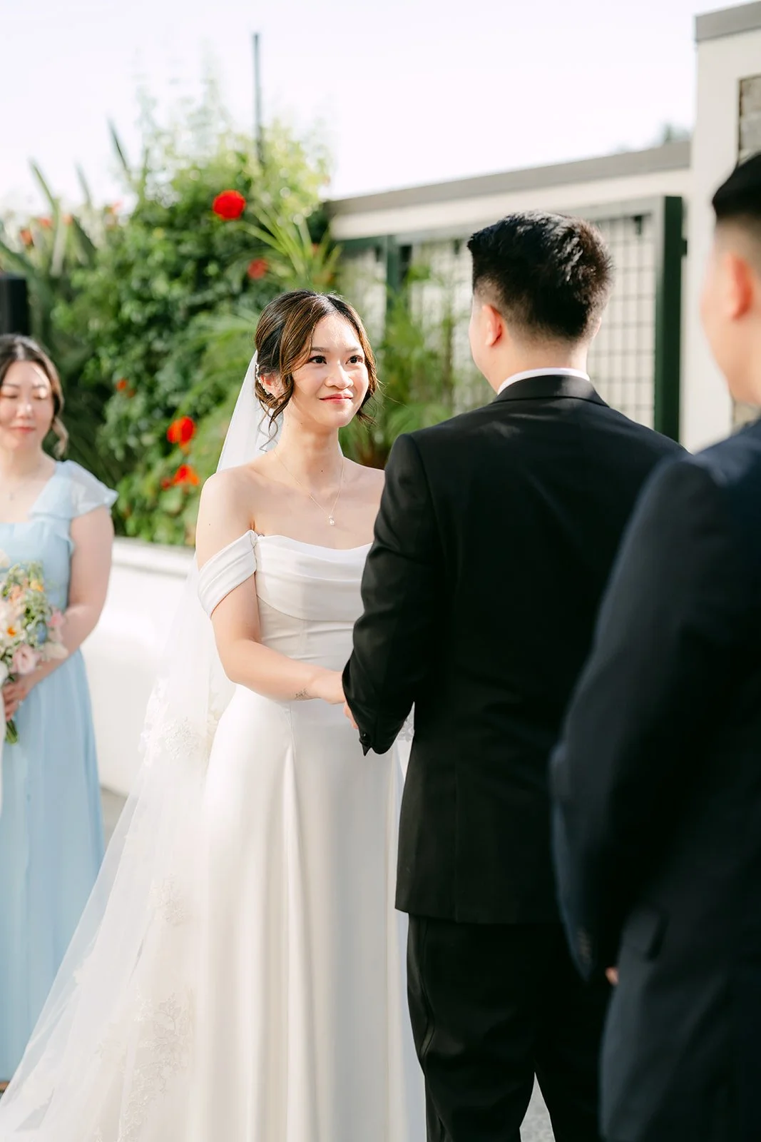 Amanda and San holding hands during their vows.