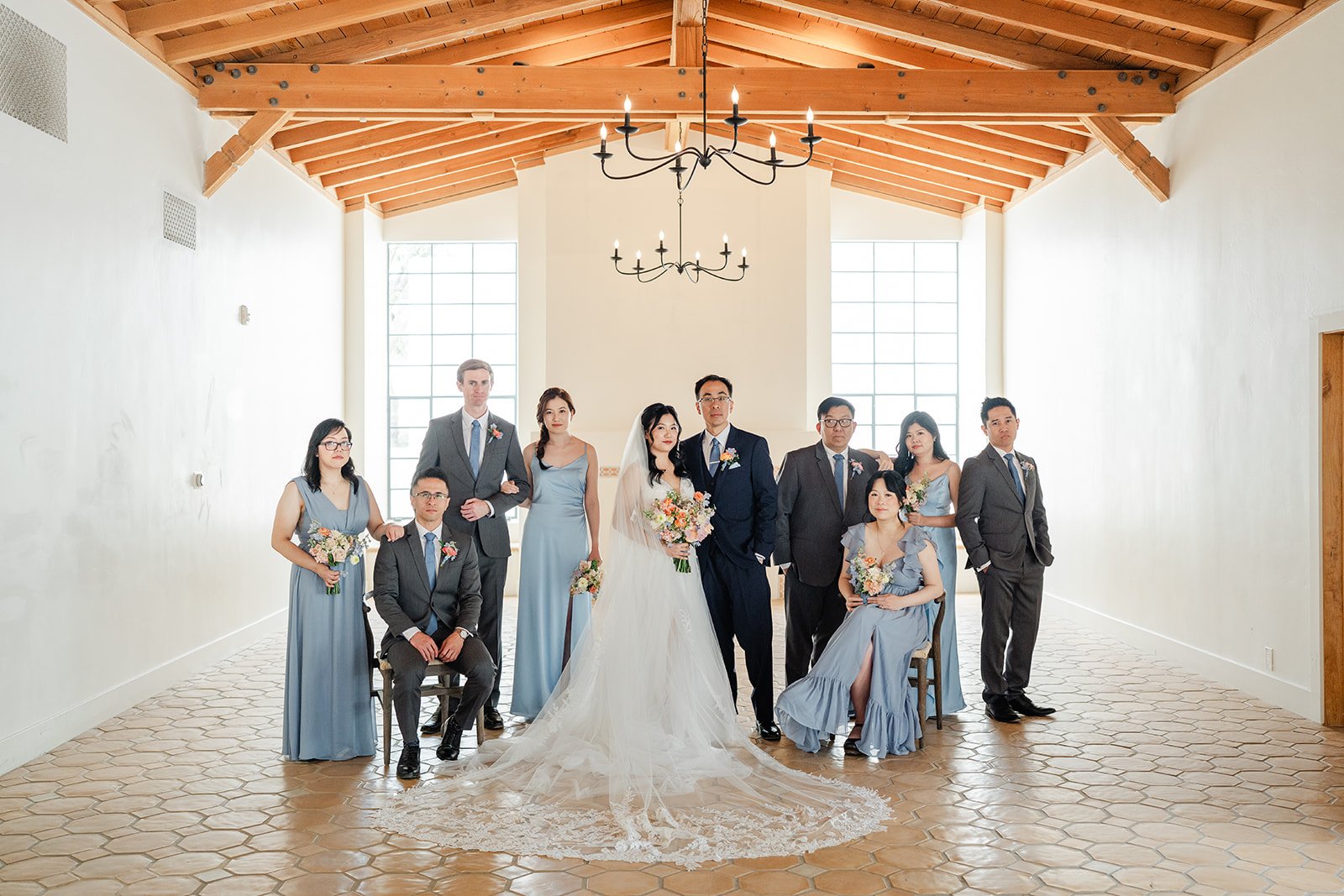 Full wedding party in the hall under the timber trusses