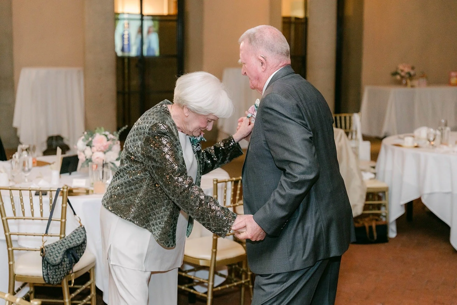 Two guests dancing together beside the tables