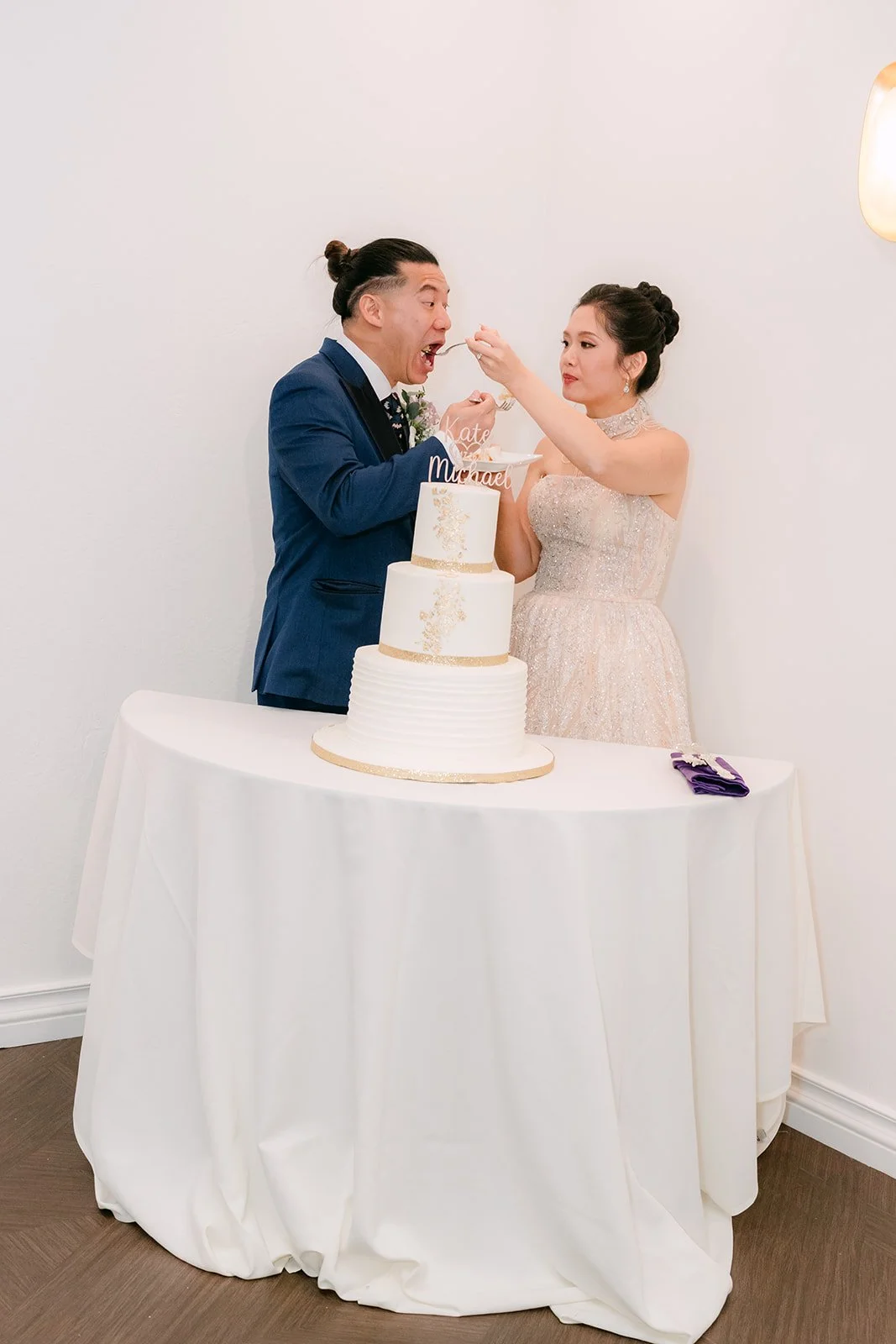 Kate and Michael smiling beside their cake.