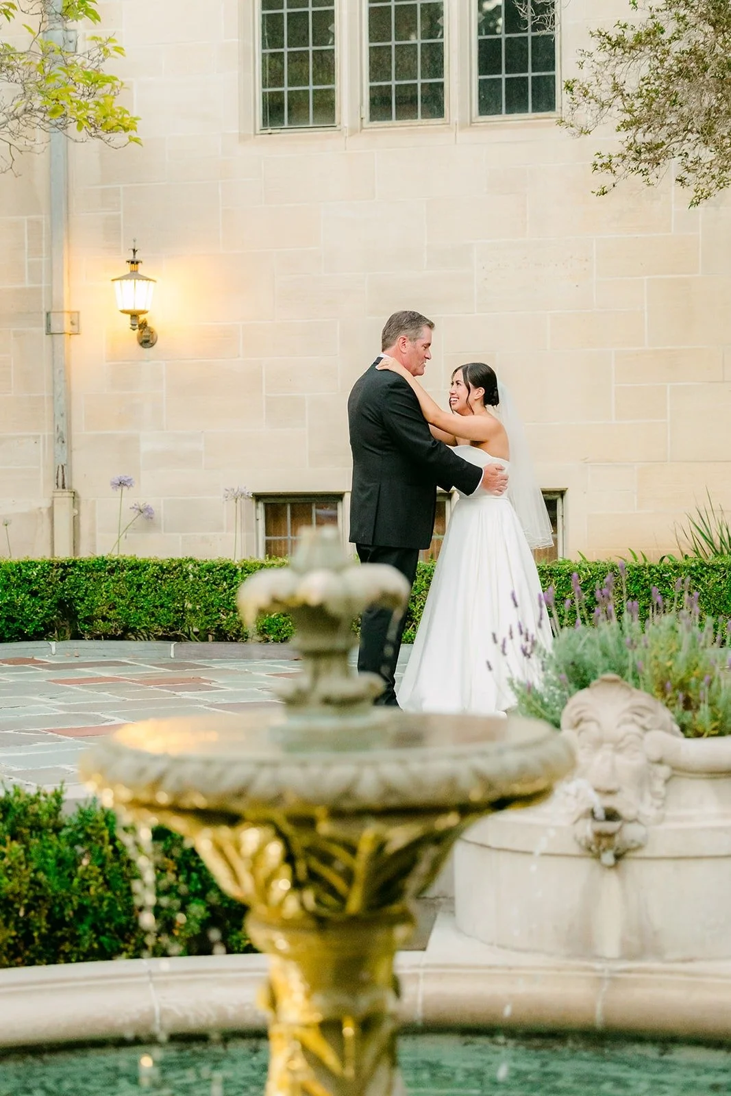 Brianna's parent dance framed by the courtyard fountain