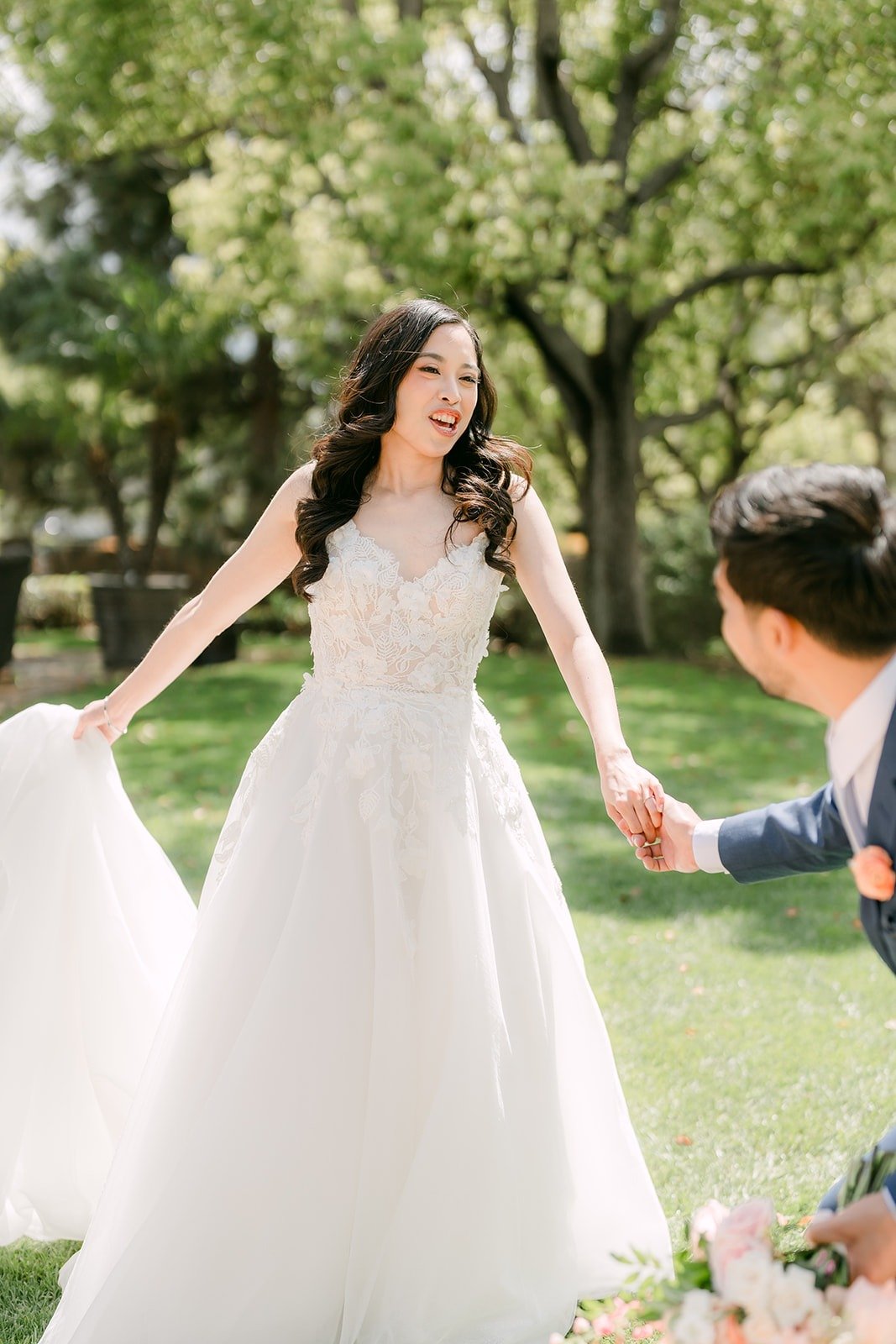 Natalie twirling her gown while holding Mark's hand