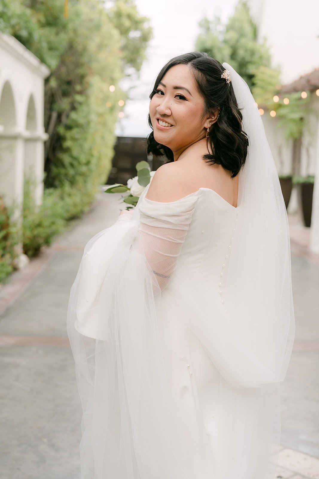 Vivian smiling over her shoulder in her long sleeve gown