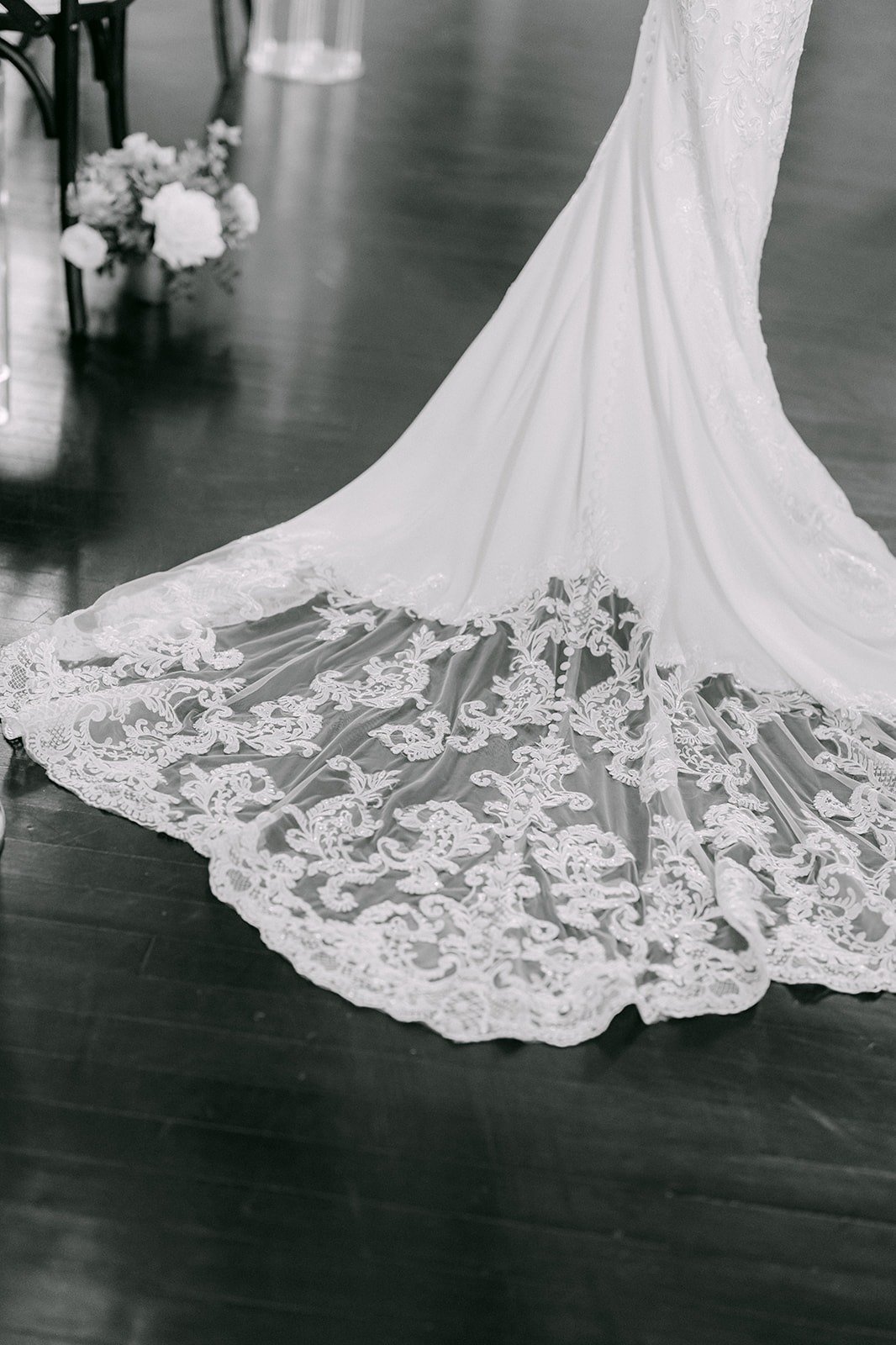 The lace train of Elisa's gown spread across the dark wood floor