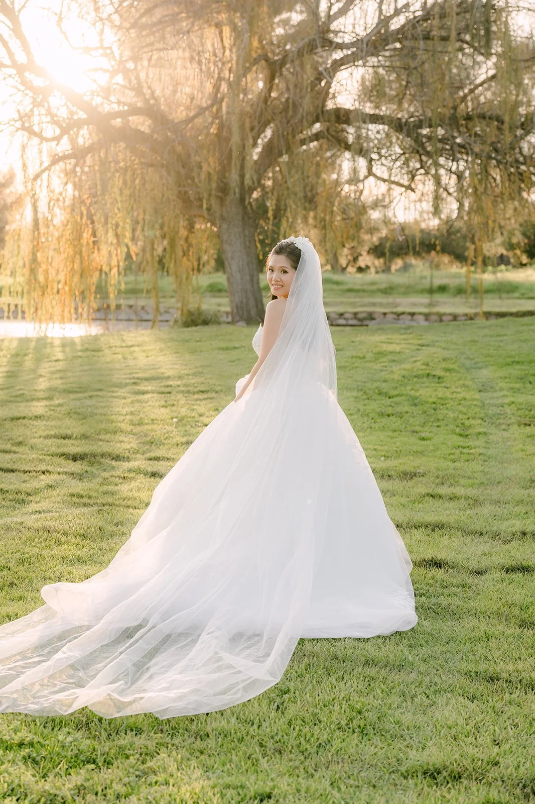 Kate standing on the lawn with her veil trailing behind her.