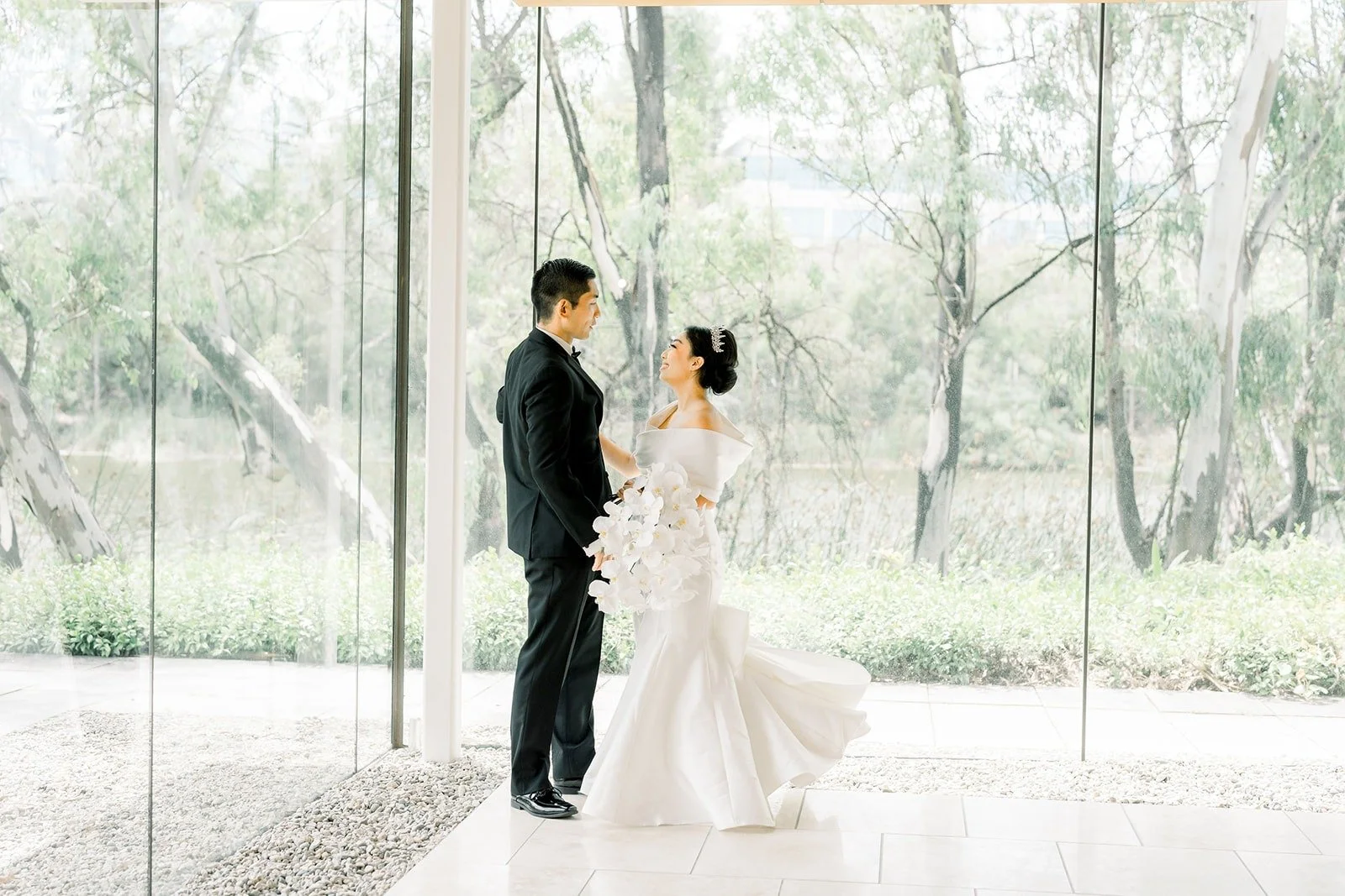 Steven and Jacinda along the glass walkway with trees beyond