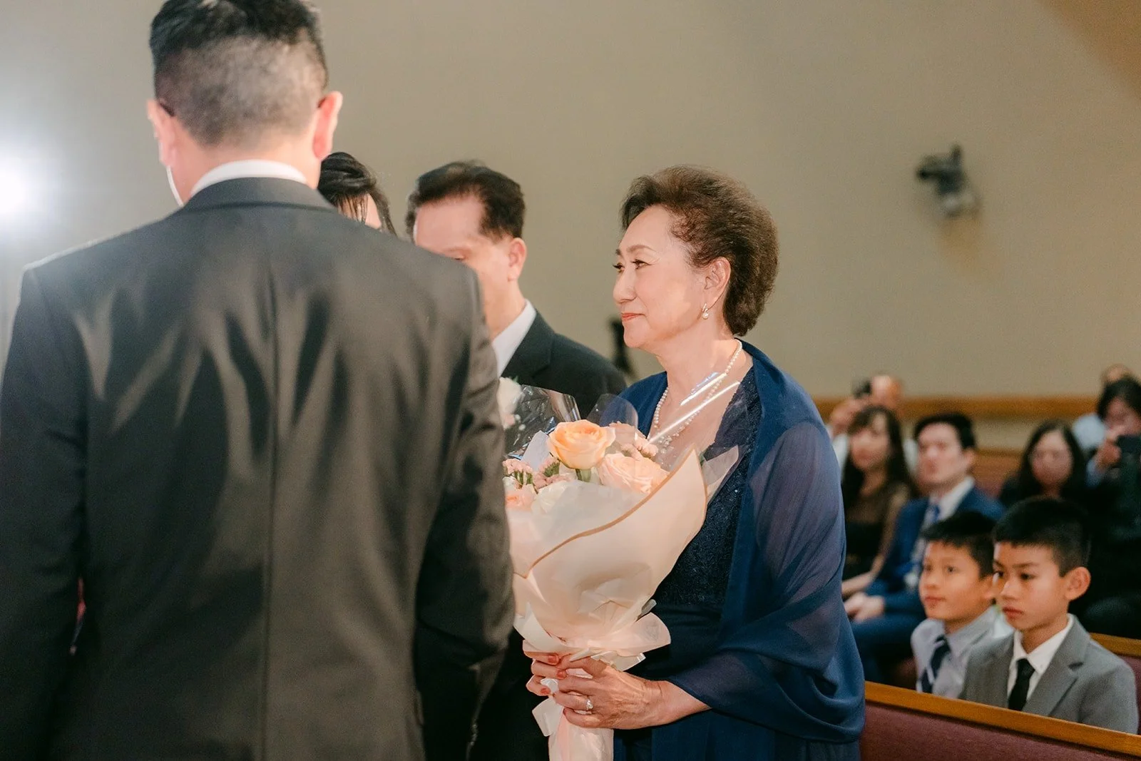 Eric hands flowers to a family member during the appreciation for the parents