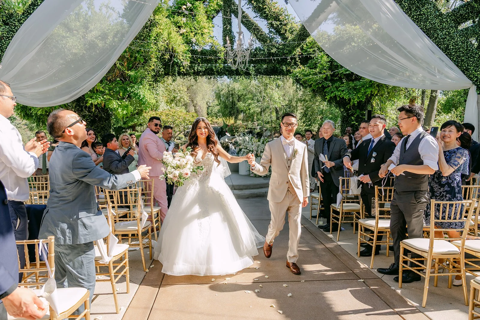 Sandra and Kevin walking back up the aisle as guests cheer.