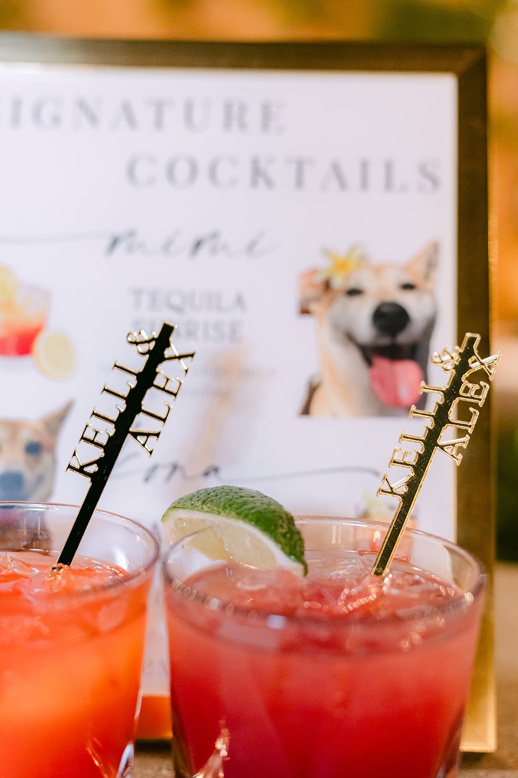 Tequila Sunrise and Bay Breeze signature cocktails in front of their sign