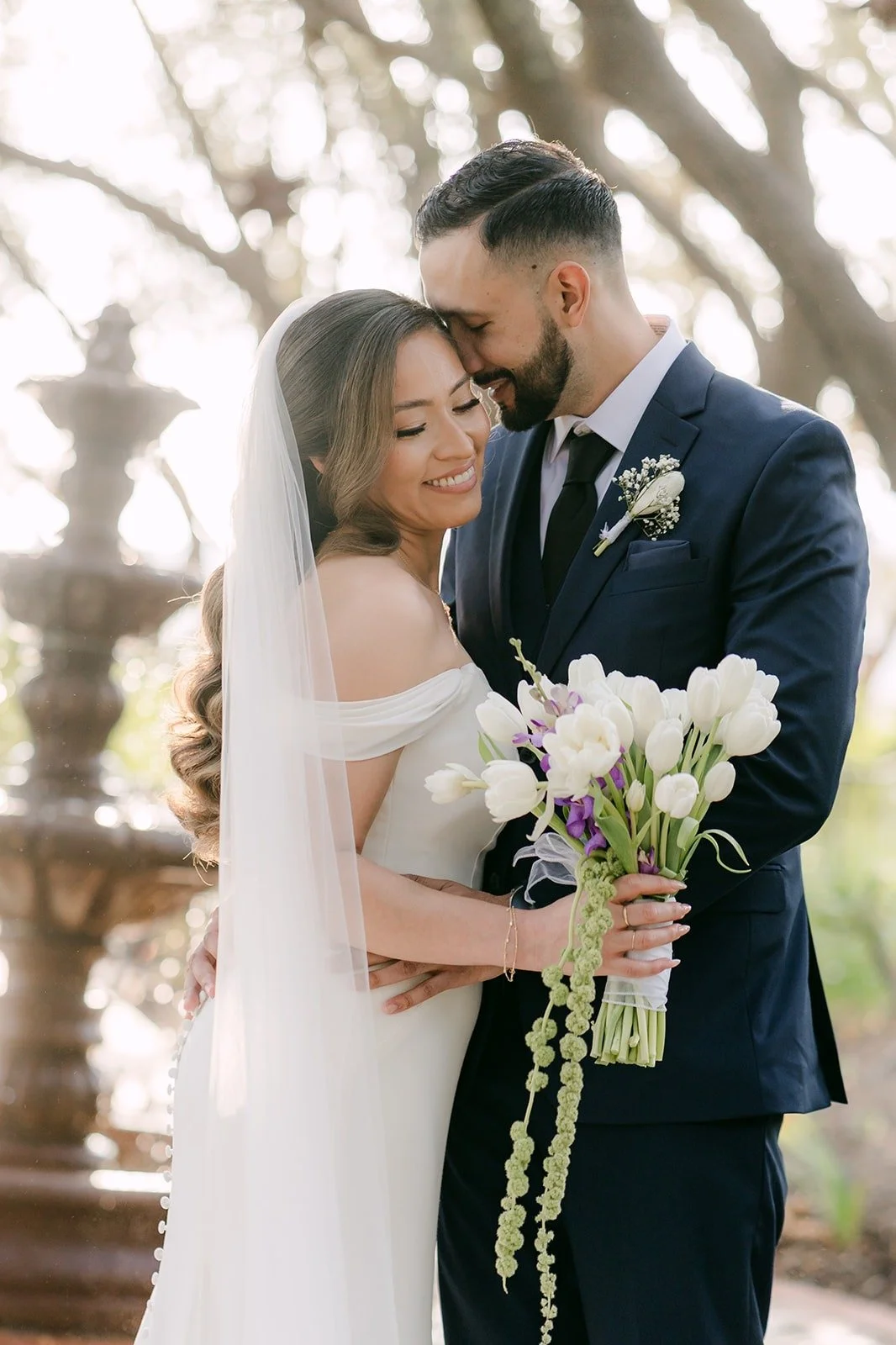 Mariana resting her head on Danny's shoulder beside the fountain