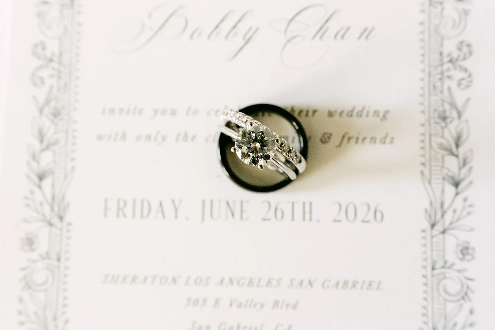 Close-up of the wedding rings on the invitation for June 26, 2026.