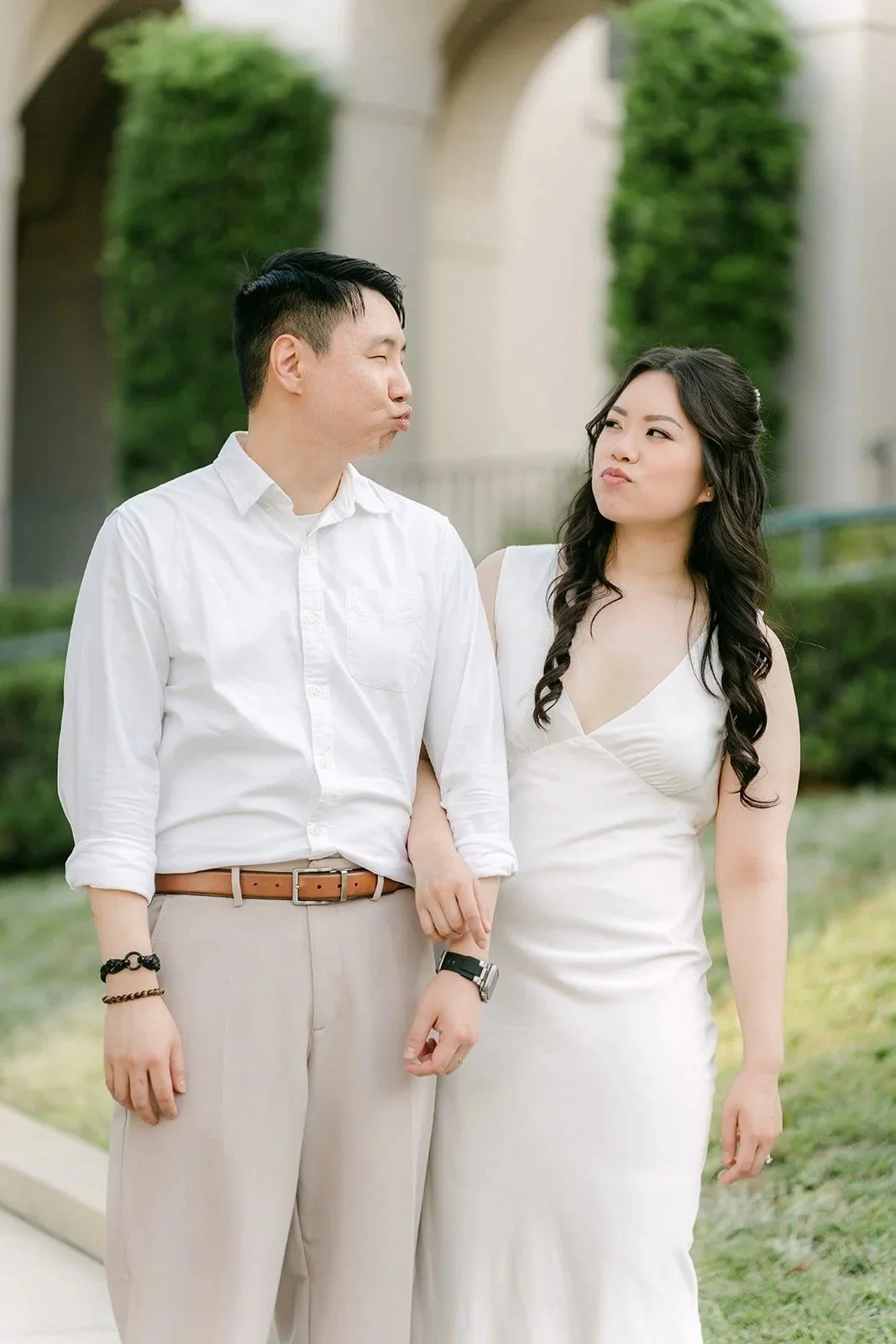 Emily and James in white and khaki in the garden courtyard of Pasadena City Hall.