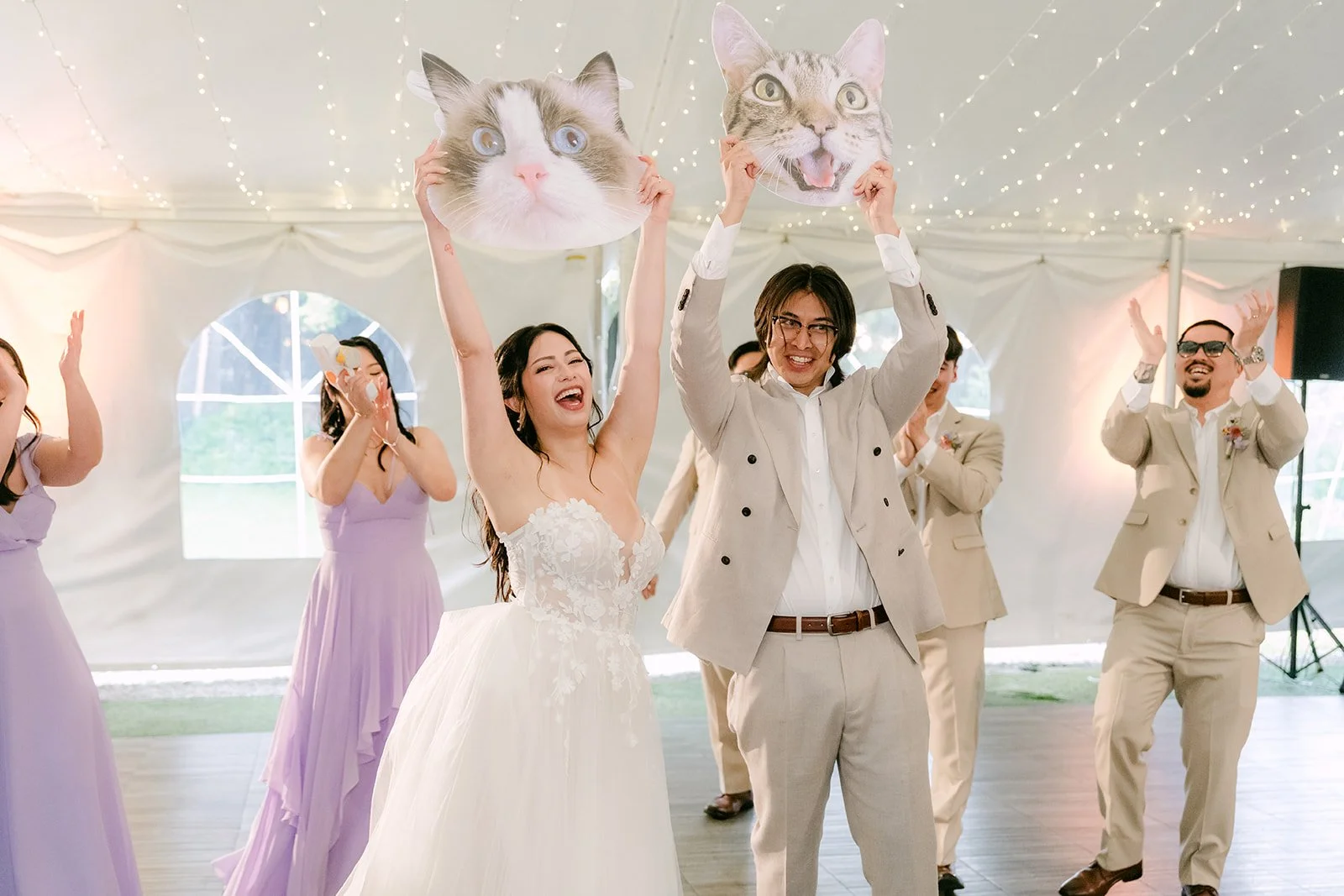 Kat and Mike holding cat face cutouts high during their grand entrance