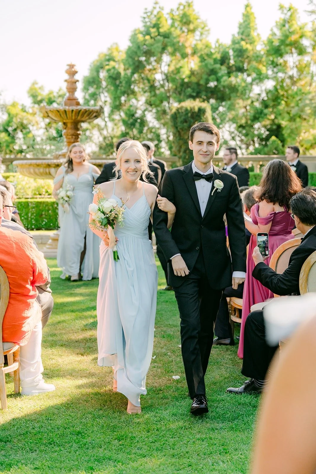 Bridesmaids and groomsmen walking back up the aisle