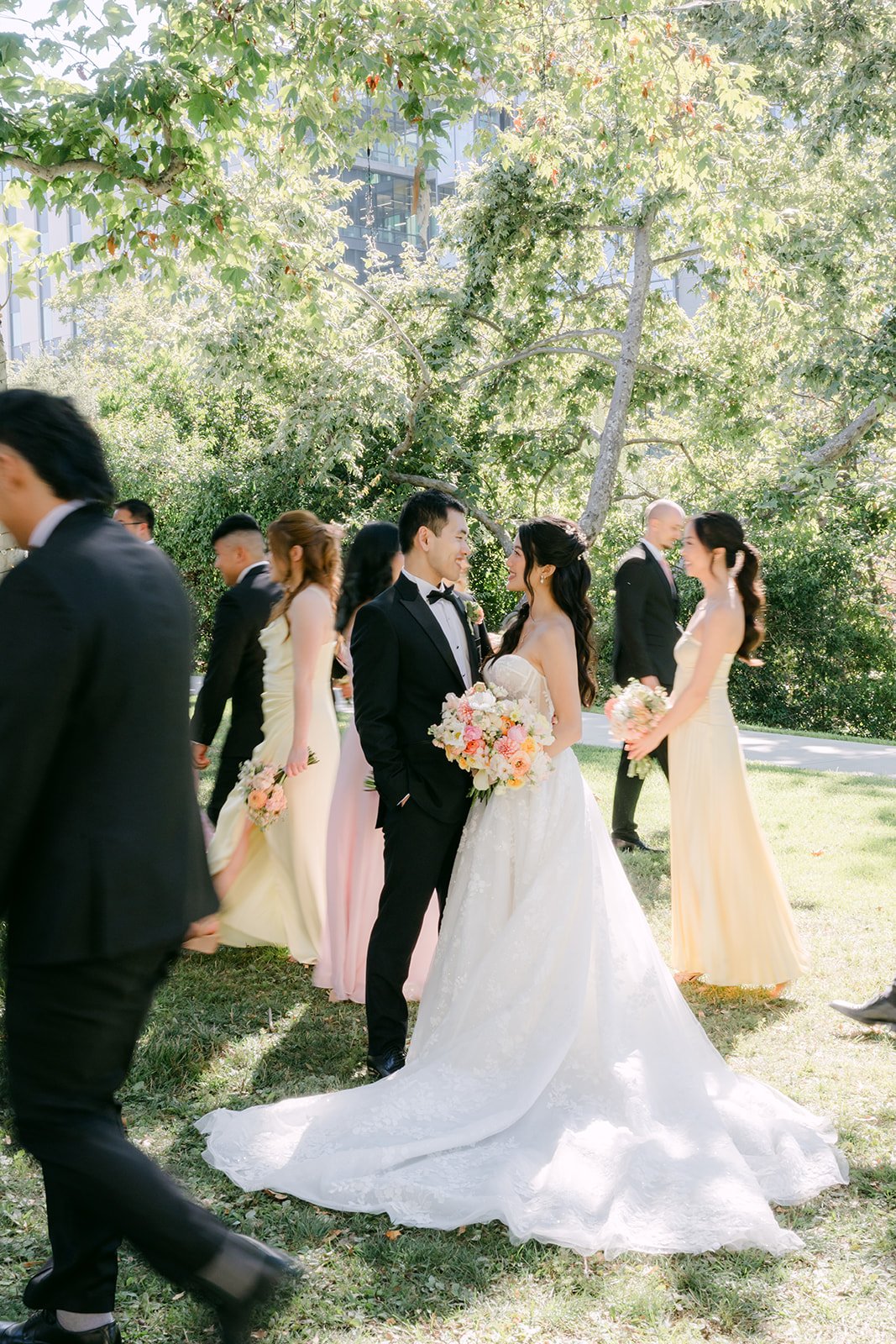 The wedding party walking together through the garden