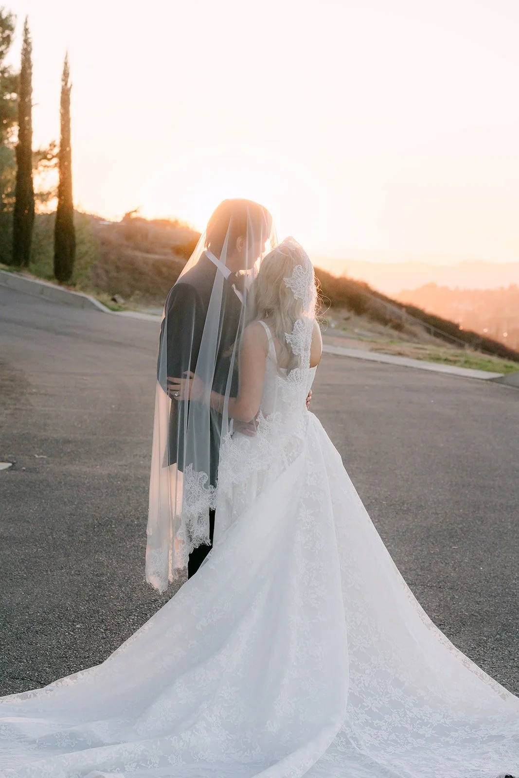 Konitha and Job kissing as the sun sets over the hills