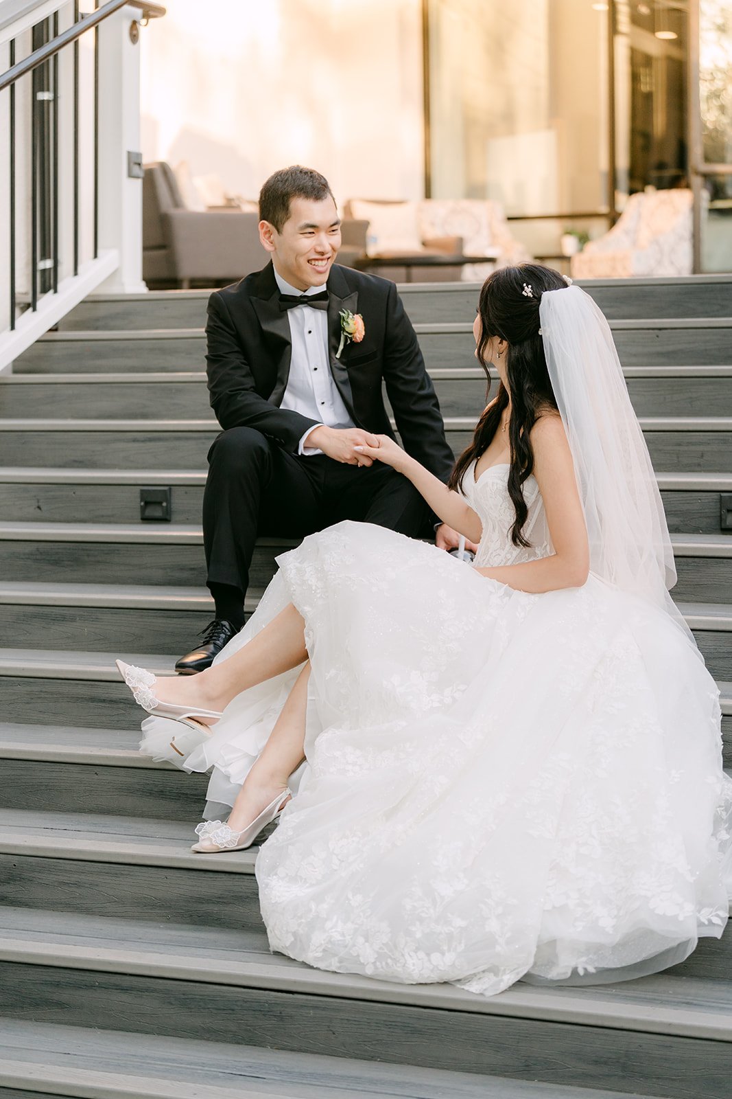 Clarissa and Austin seated on the steps, photographed by One and Only Production