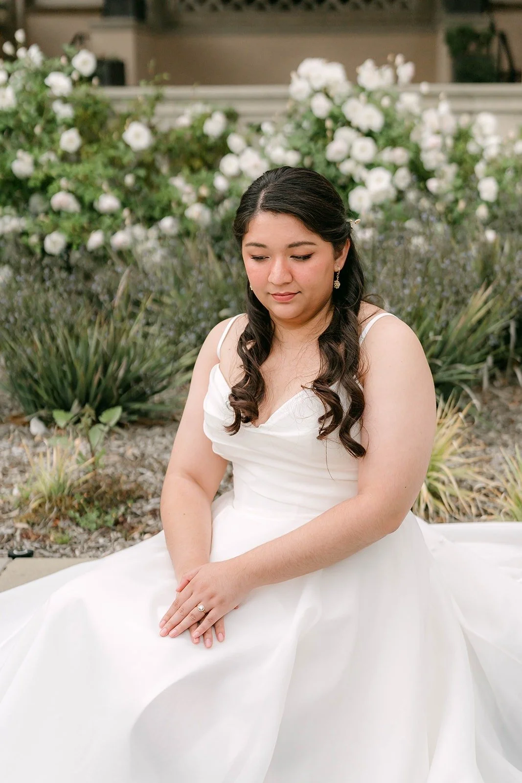 Saira seated in front of white roses near the Athenaeum entrance