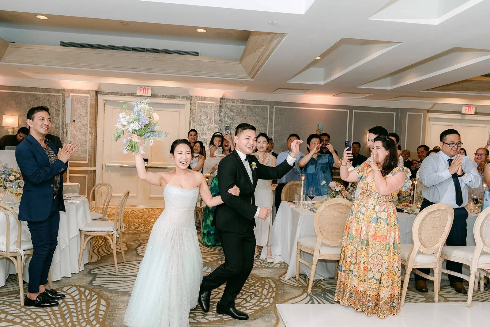 Kylie and Mario dancing through the doors as guests cheer
