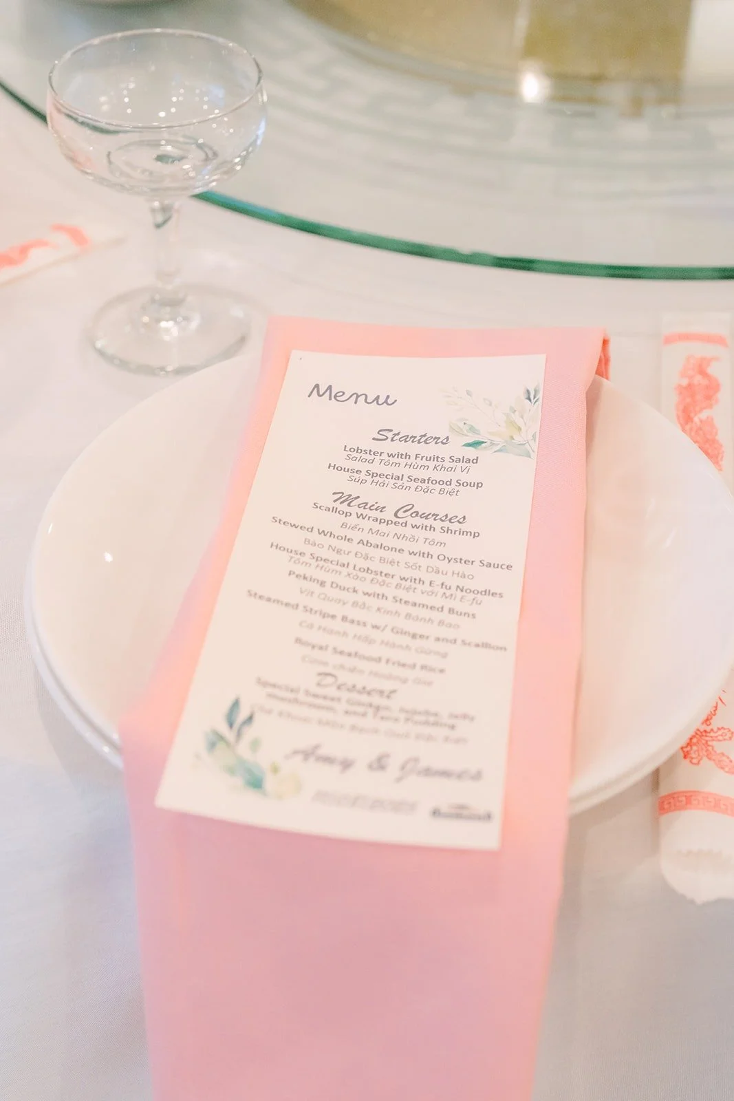Pink menu card on a place setting with gold rimmed glassware