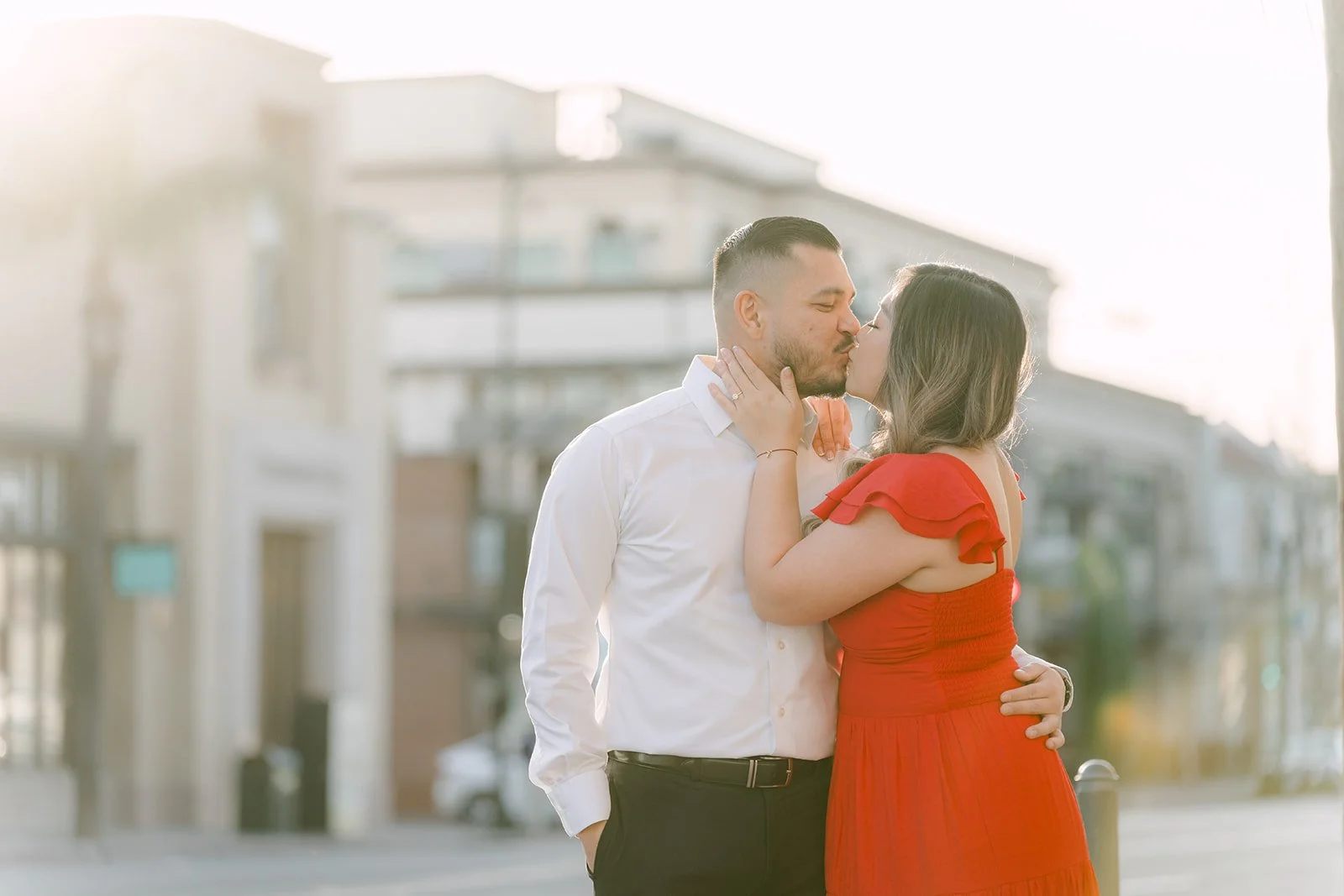 Linh and Ankush embracing on a street corner in Old Town Pasadena.