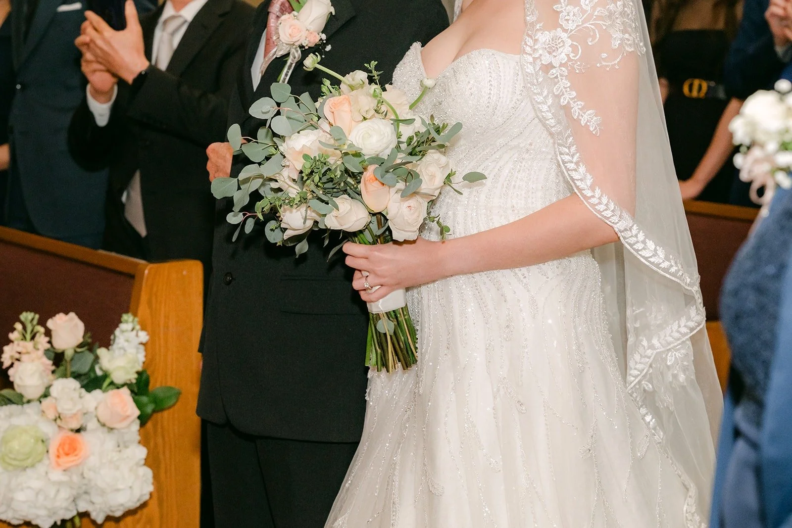 Eunice and Eric meet at the front of the church with her bouquet between them