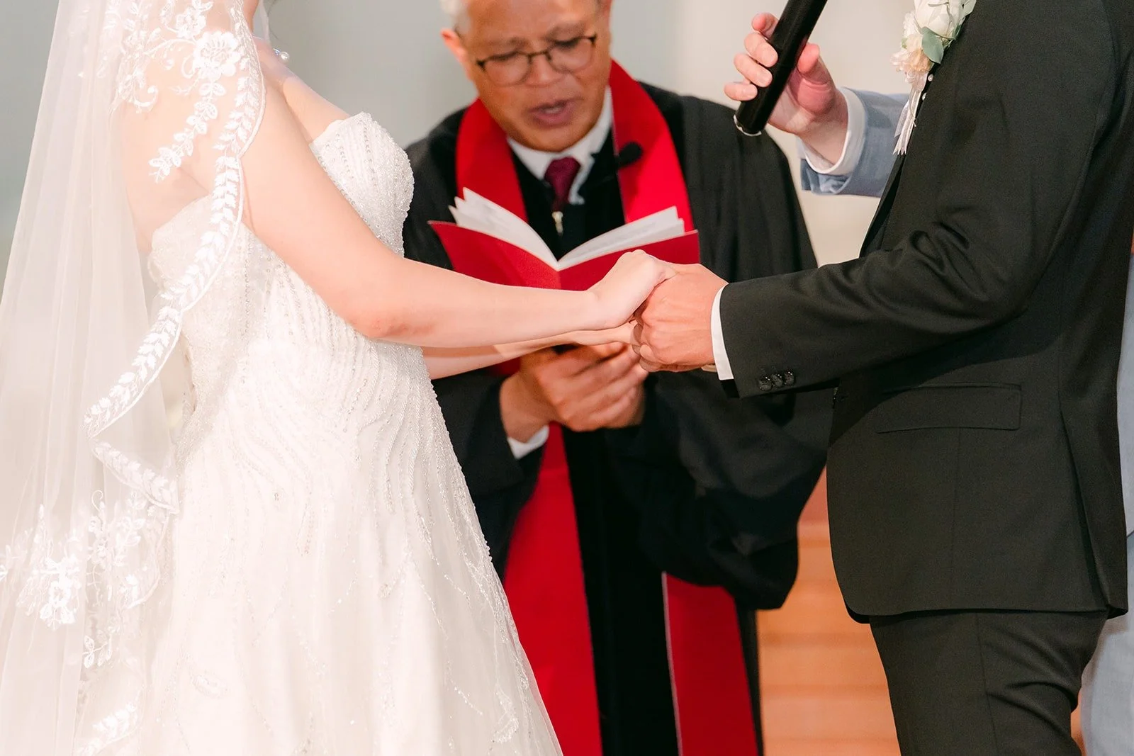 Close up of Eunice and Eric's hands as they exchange rings