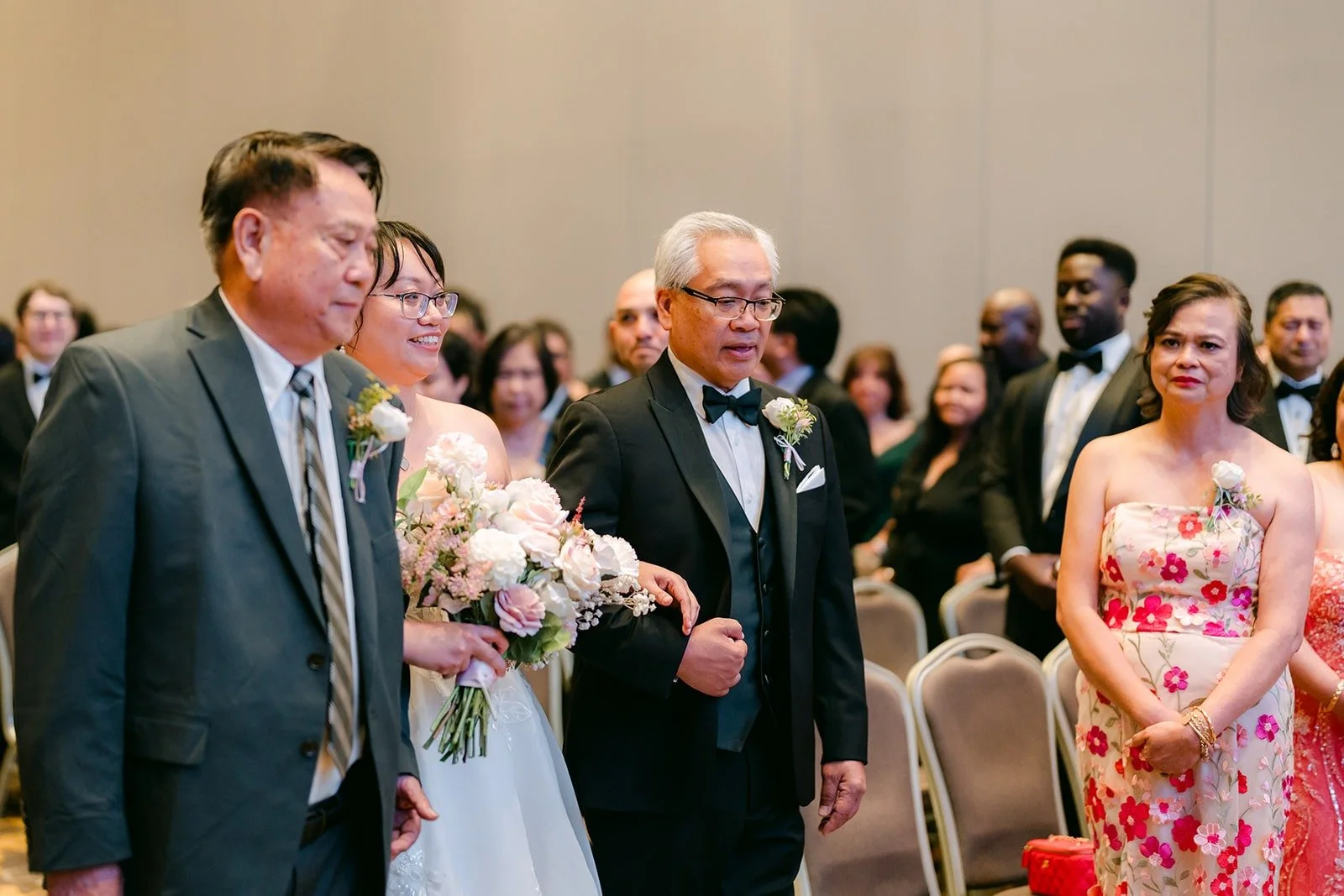 Stella walking down the aisle between two family members