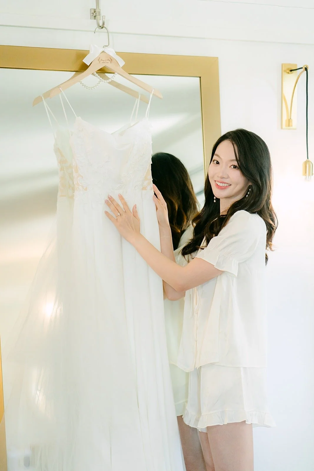 Tin reaching for her wedding dress on its hanger