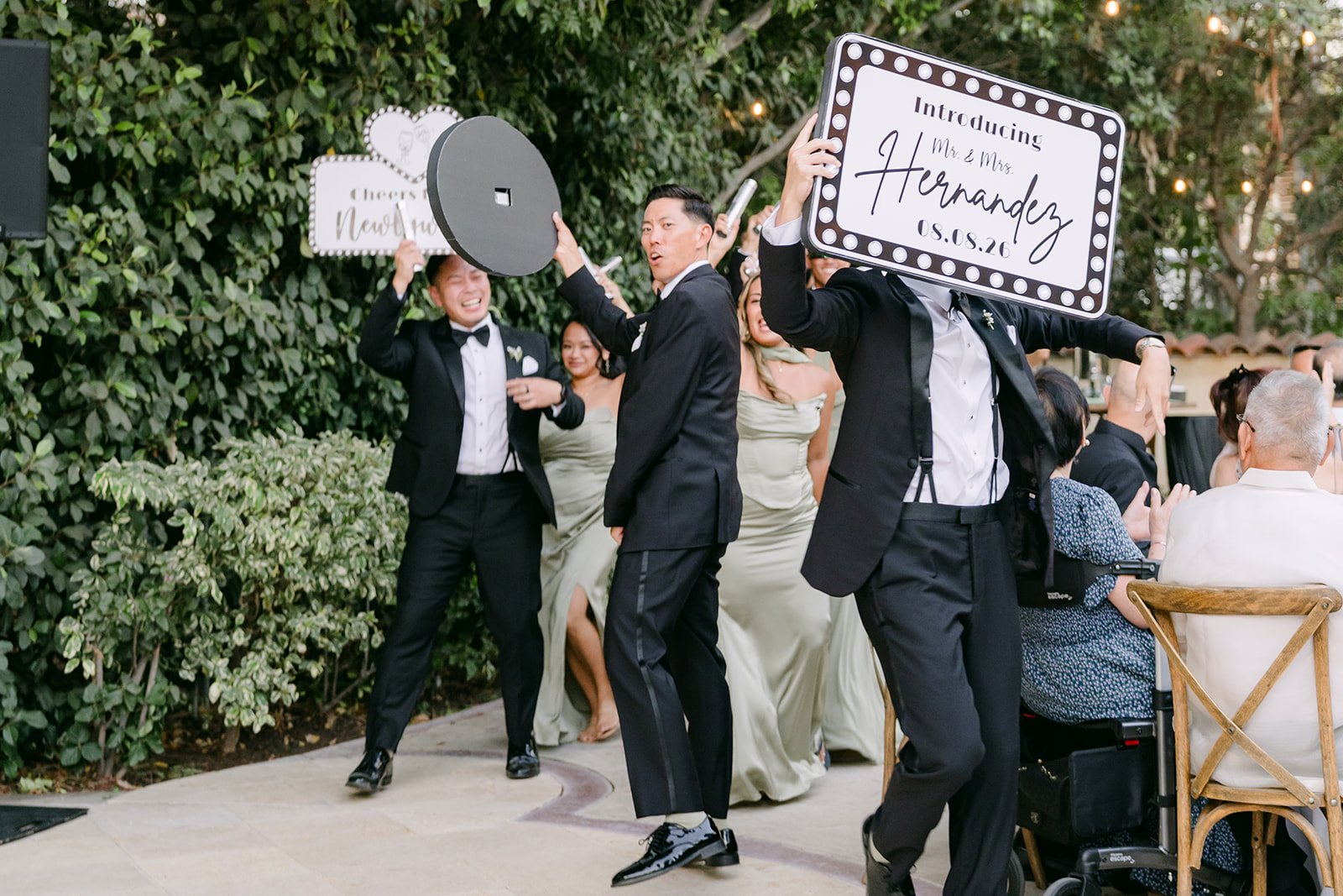Groomsmen dancing into the reception with the Hernandez sign during the grand entrance.