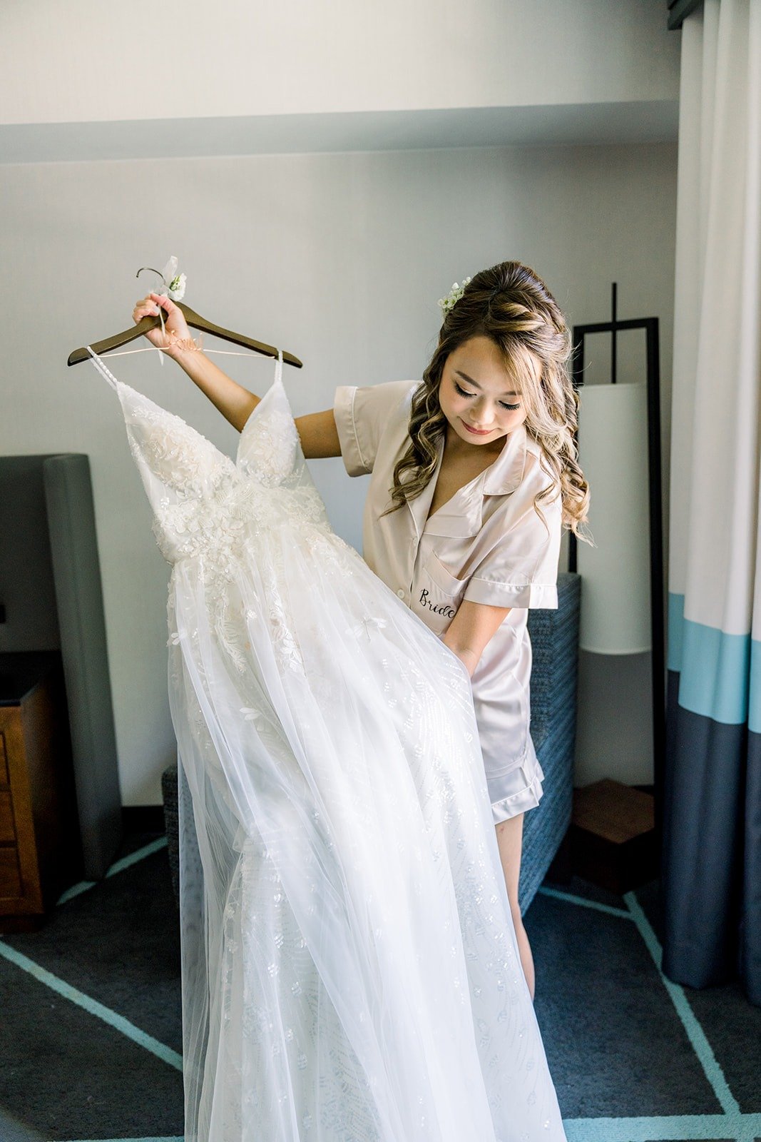 Ariel in a satin robe holding up her gown