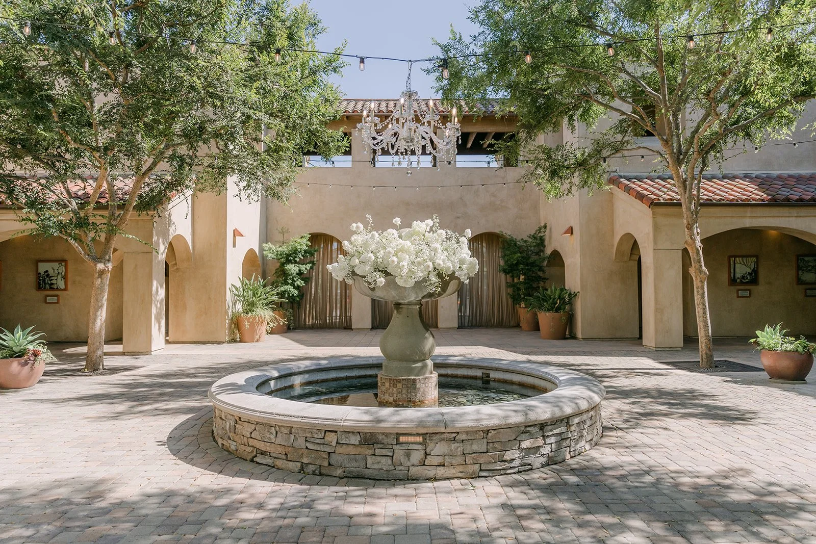 Serra Plaza courtyard fountain with a white floral arrangement
