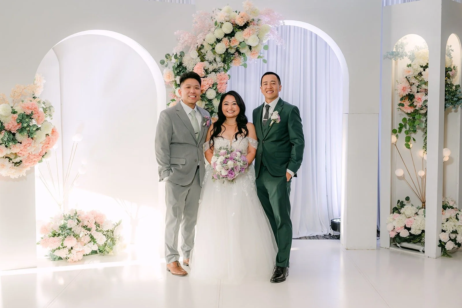 Jennifer and Kevin with guests at the floral arch during cocktail hour