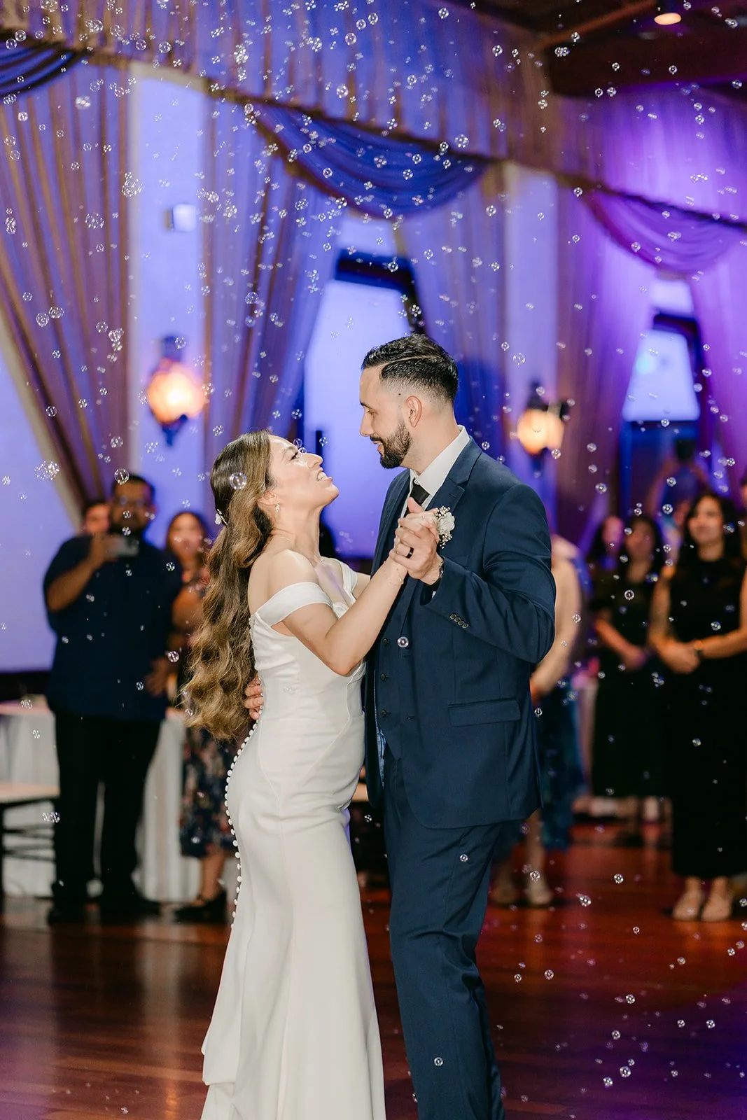 Mariana and Danny dancing under the lavender uplighting