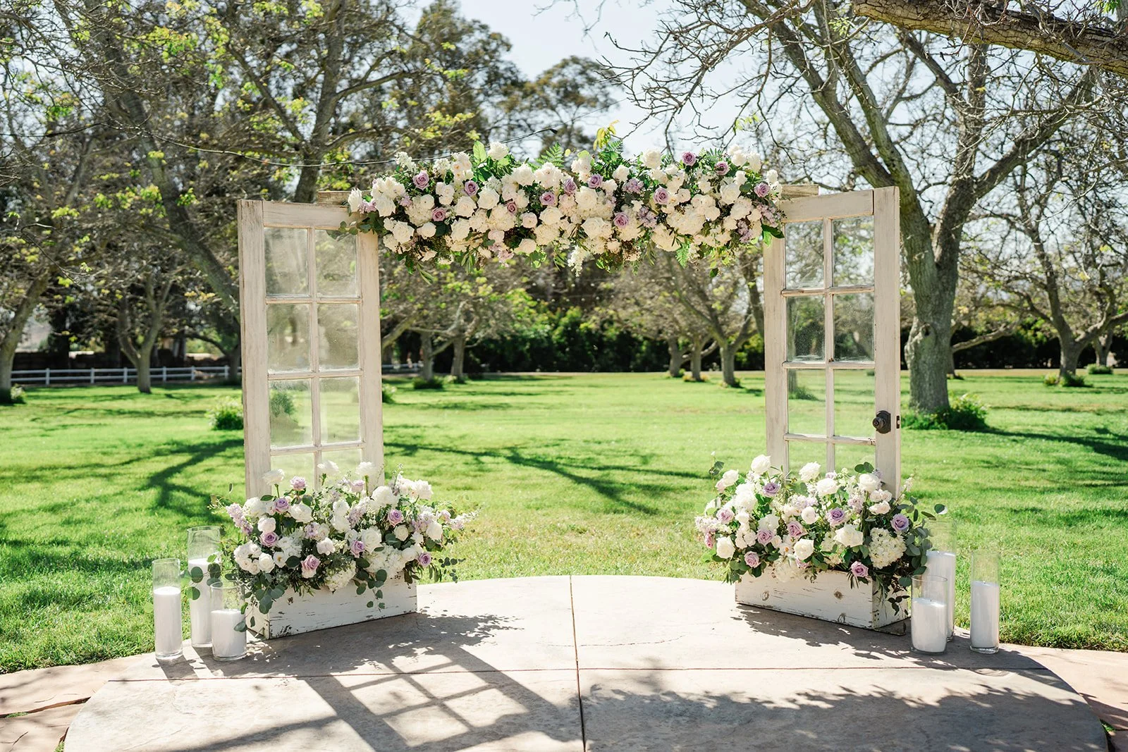 Ceremony arch of white wooden doors with ivory and blush florals