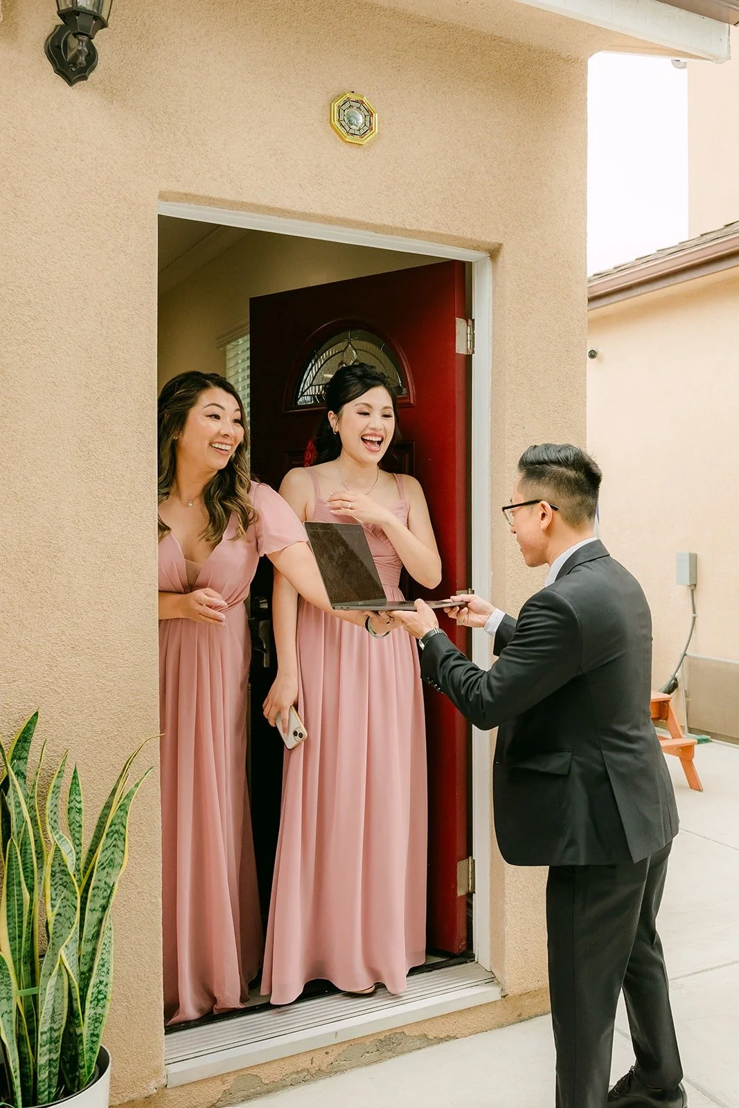 Bridesmaids in blush quizzing Alex at the front door