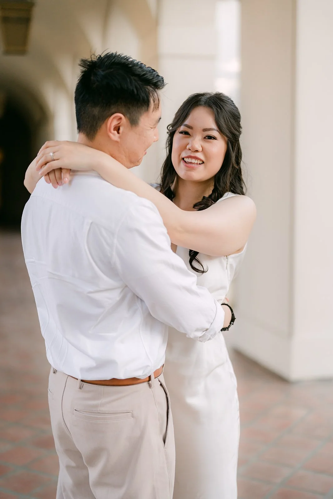 James holds Emily close beside a column in the Pasadena City Hall colonnade.