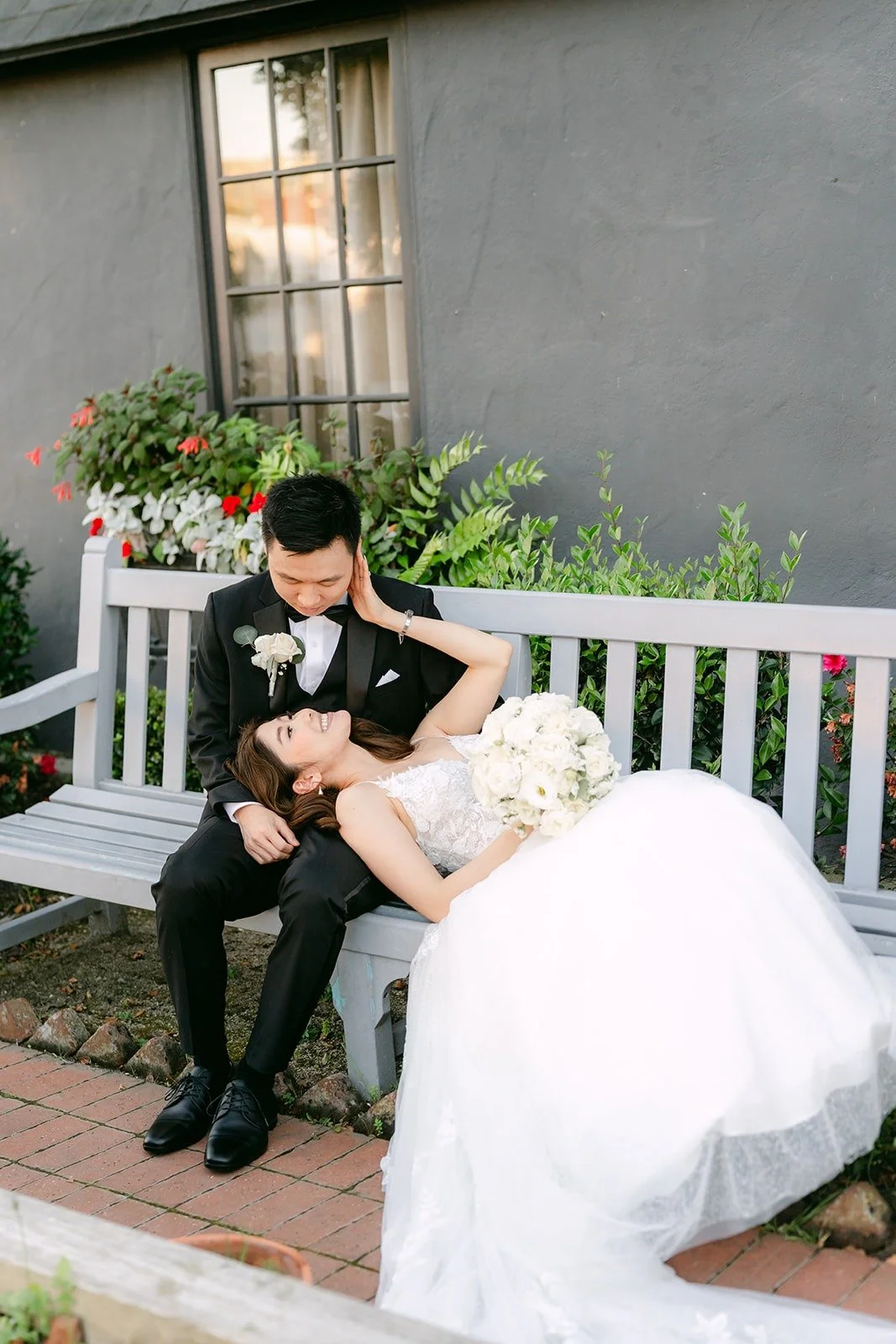 Jason holding Valerie as she leans back on a white bench