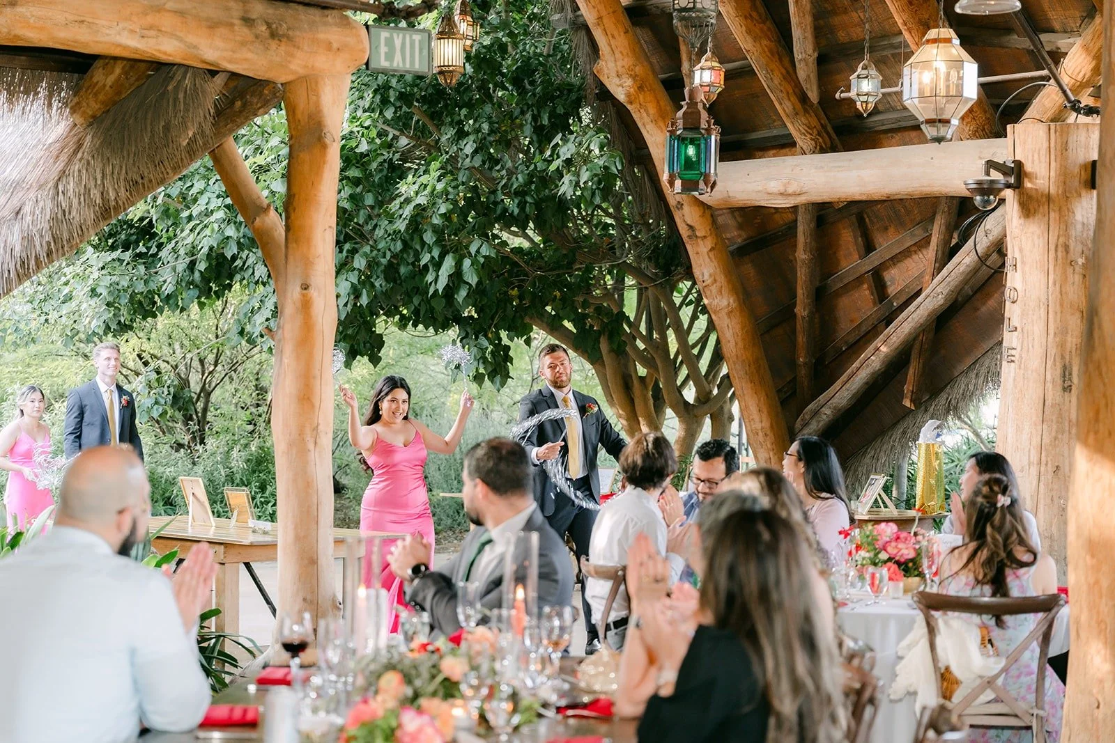 Guests cheering as the wedding party makes its entrance into the pavilion