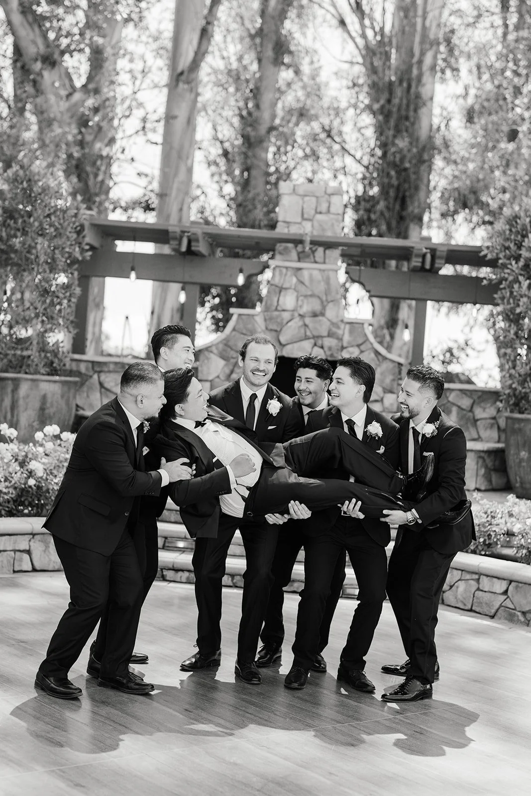 Black and white photo of the groomsmen joking around