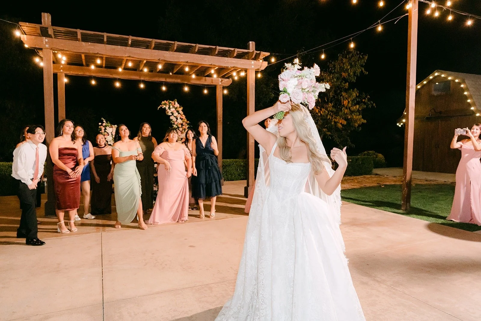 Konitha getting ready to toss her bouquet on the patio