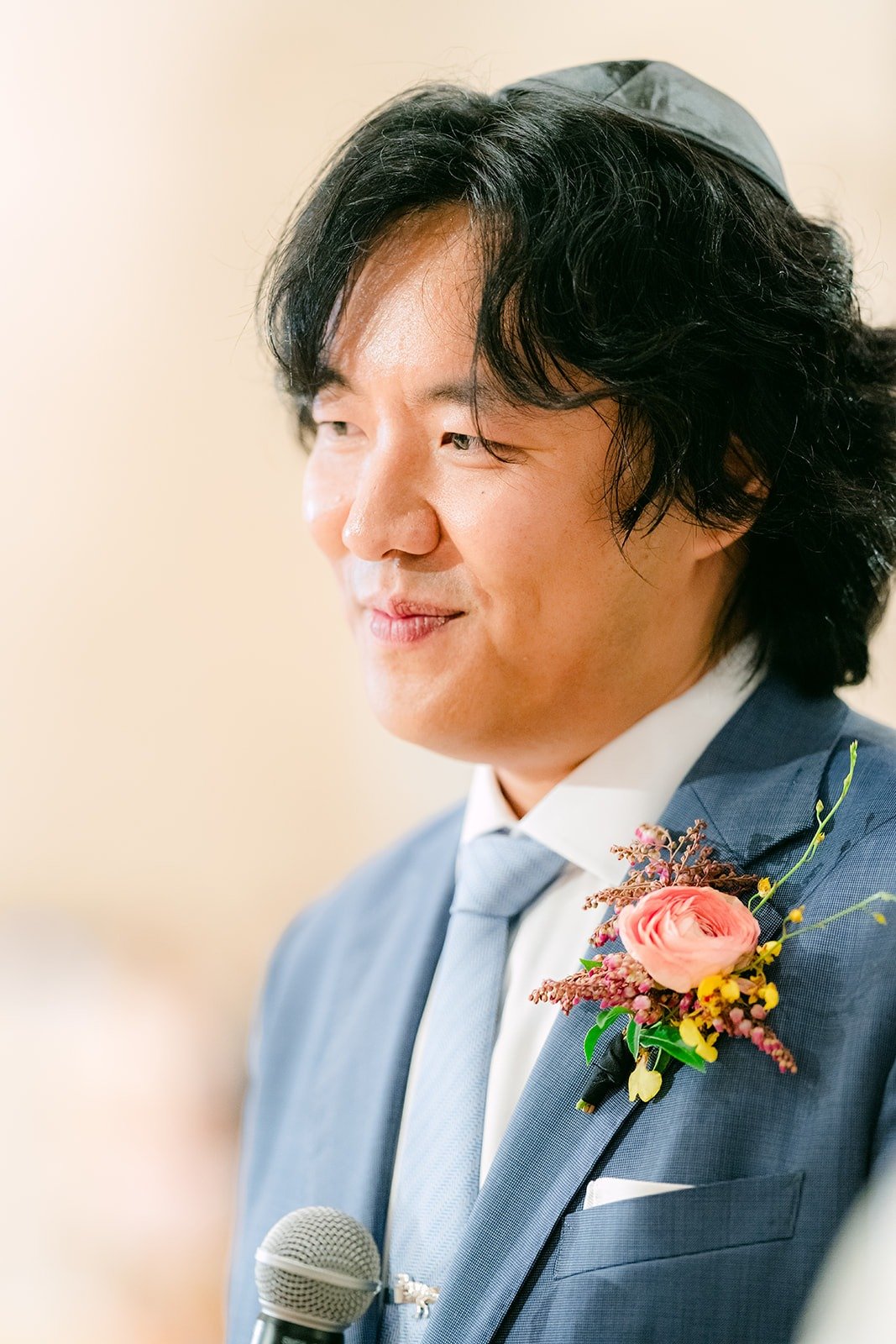 Philip listening with a peach boutonniere on his lapel