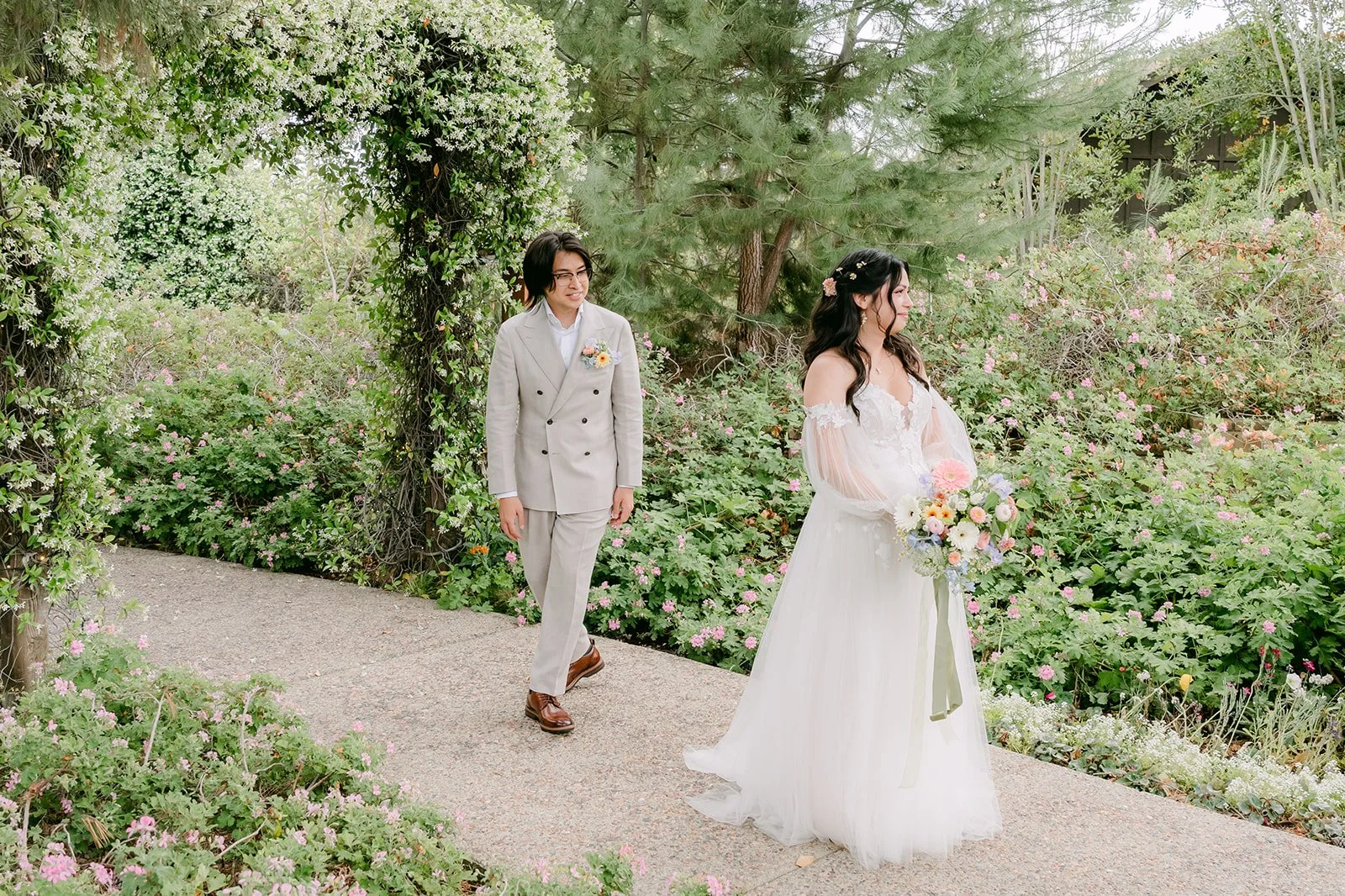 Kat and Mike walking toward each other on the garden path