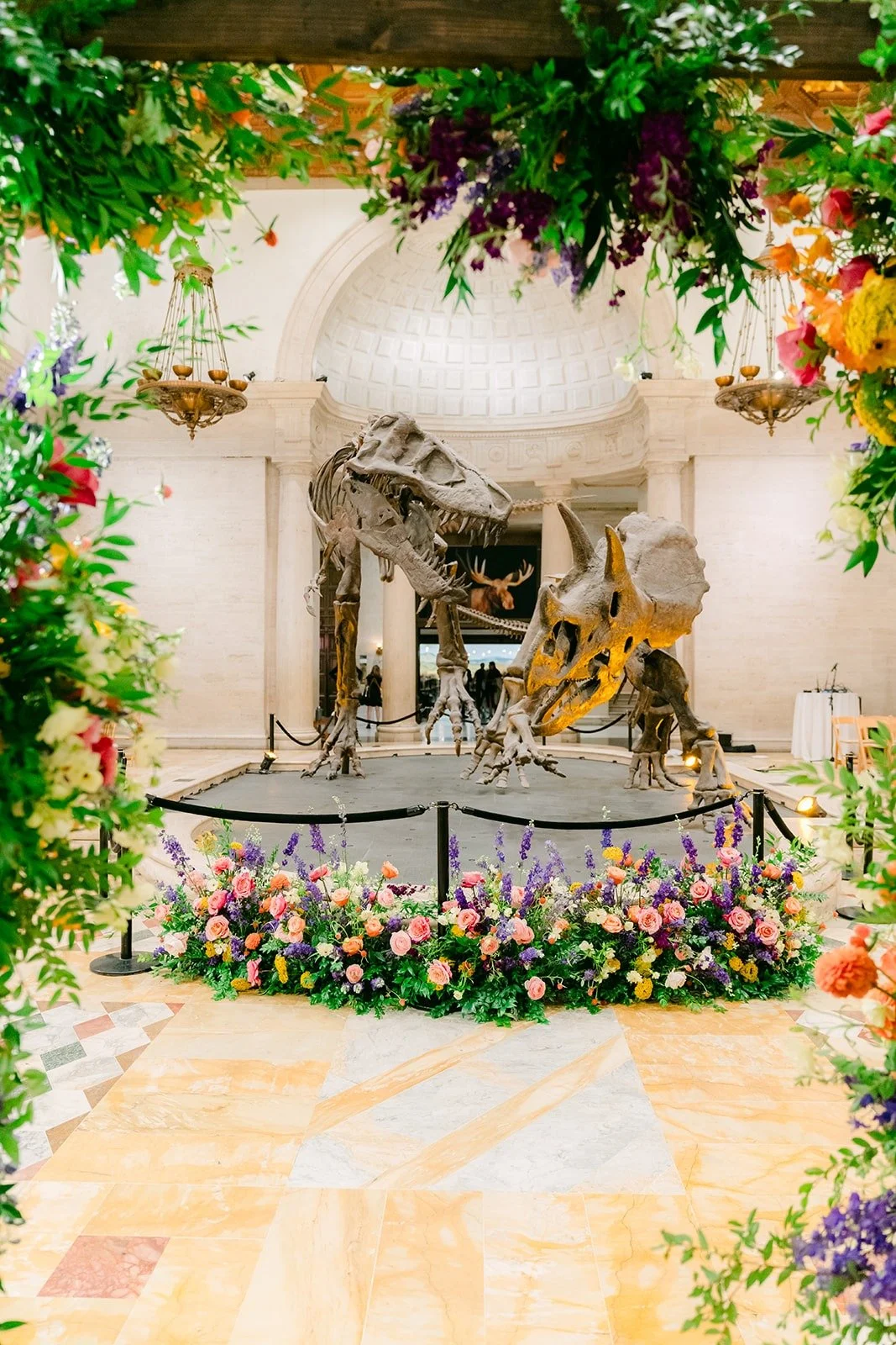 The floral arch framing the dinosaur display for the ceremony