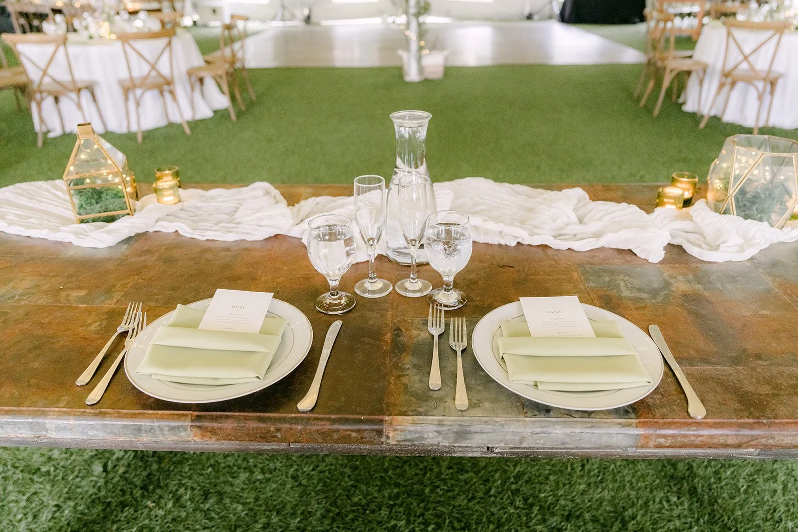 Place setting with a sage napkin on a wooden farm table