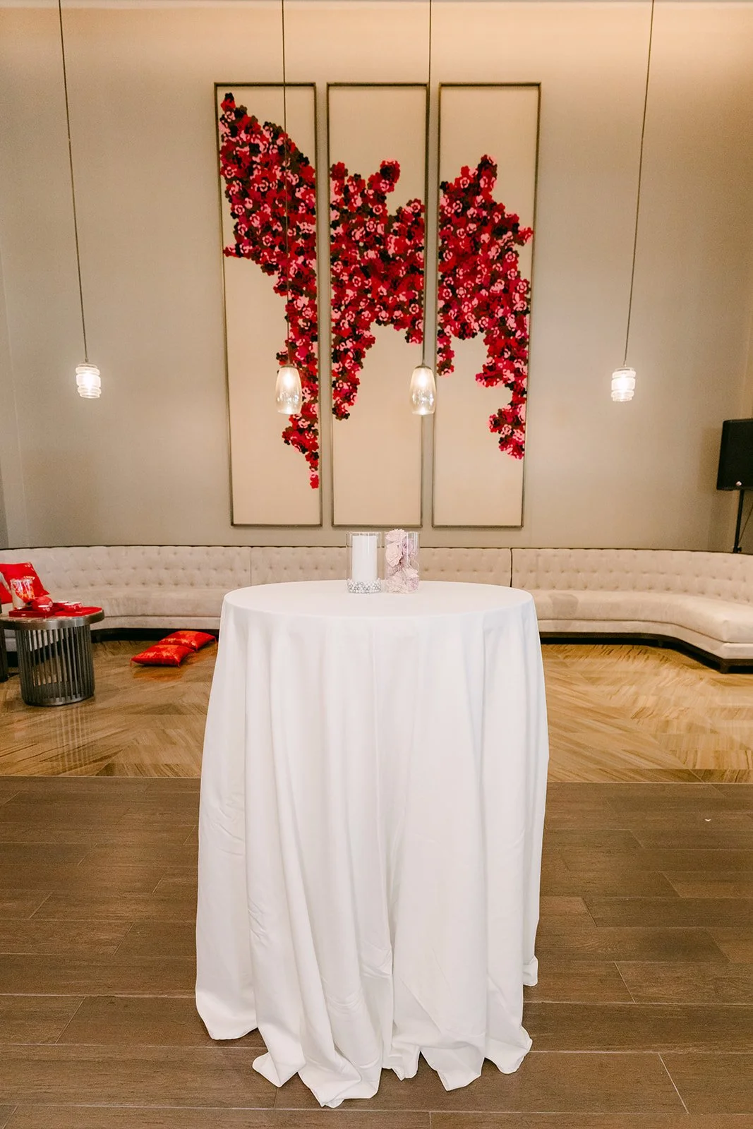 Cocktail table in front of the red floral wall.