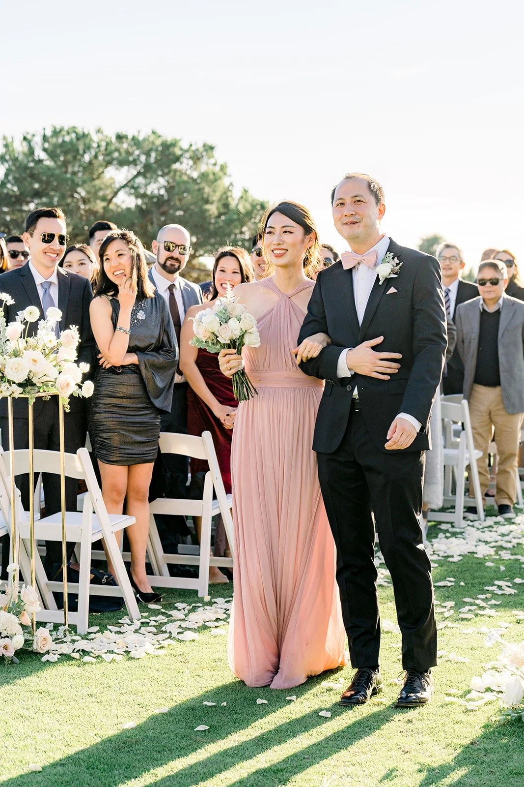 A bridesmaid and groomsman walking back up the aisle, photographed by One and Only Production